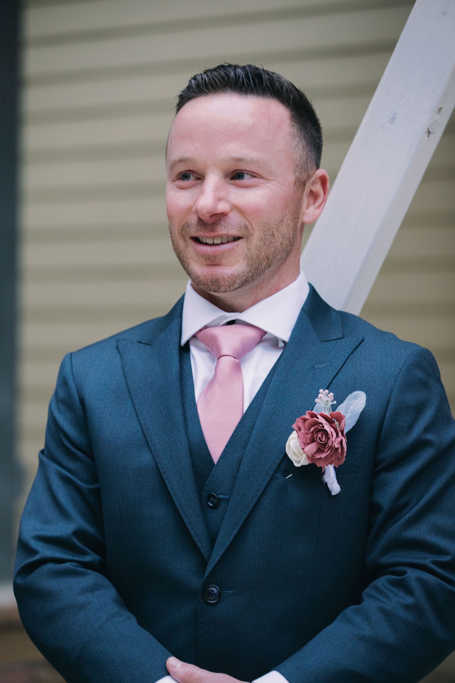 Groom smiles as bride walks down aisle