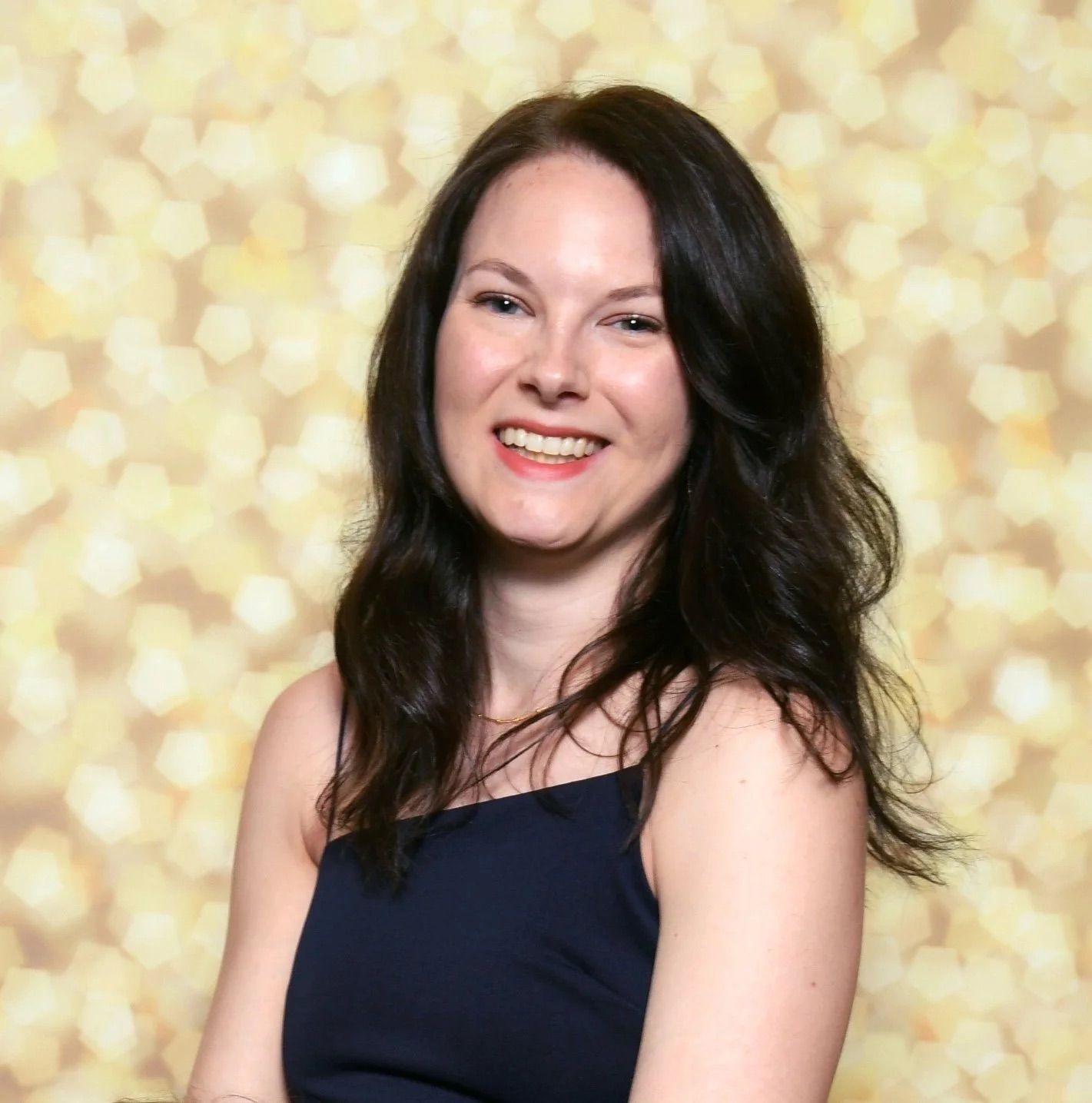 Dark hair woman in front of gold backgrond