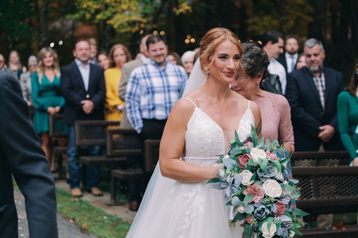 Bride walking down aisle and smiles at groom