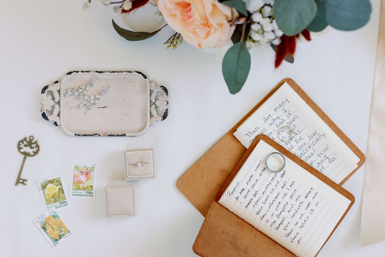 photo of wedding details for bride and groom including flowers, rings, vows