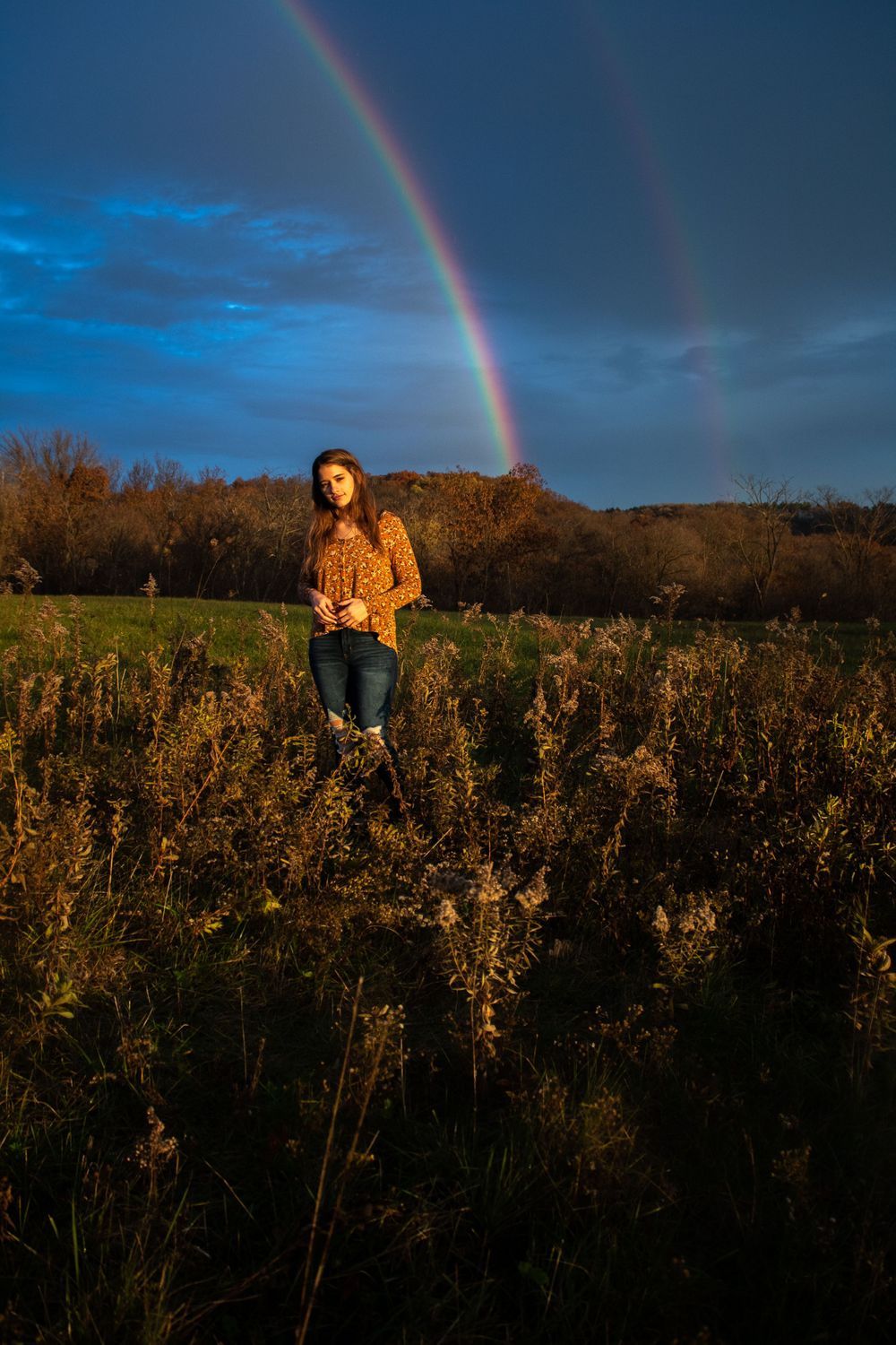 Beautiful rainbow arches across dramatic evening sky over autumn field. Mauston photographer.