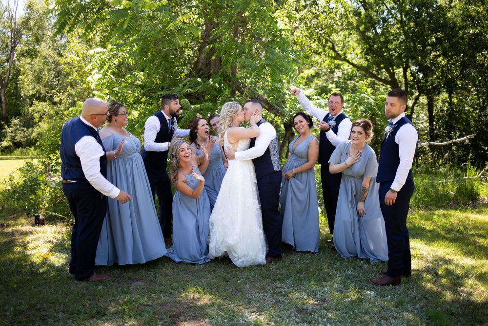 Wedding party group photos taken outdoors with bridesmaids in blue dresses. Mauston photographer.