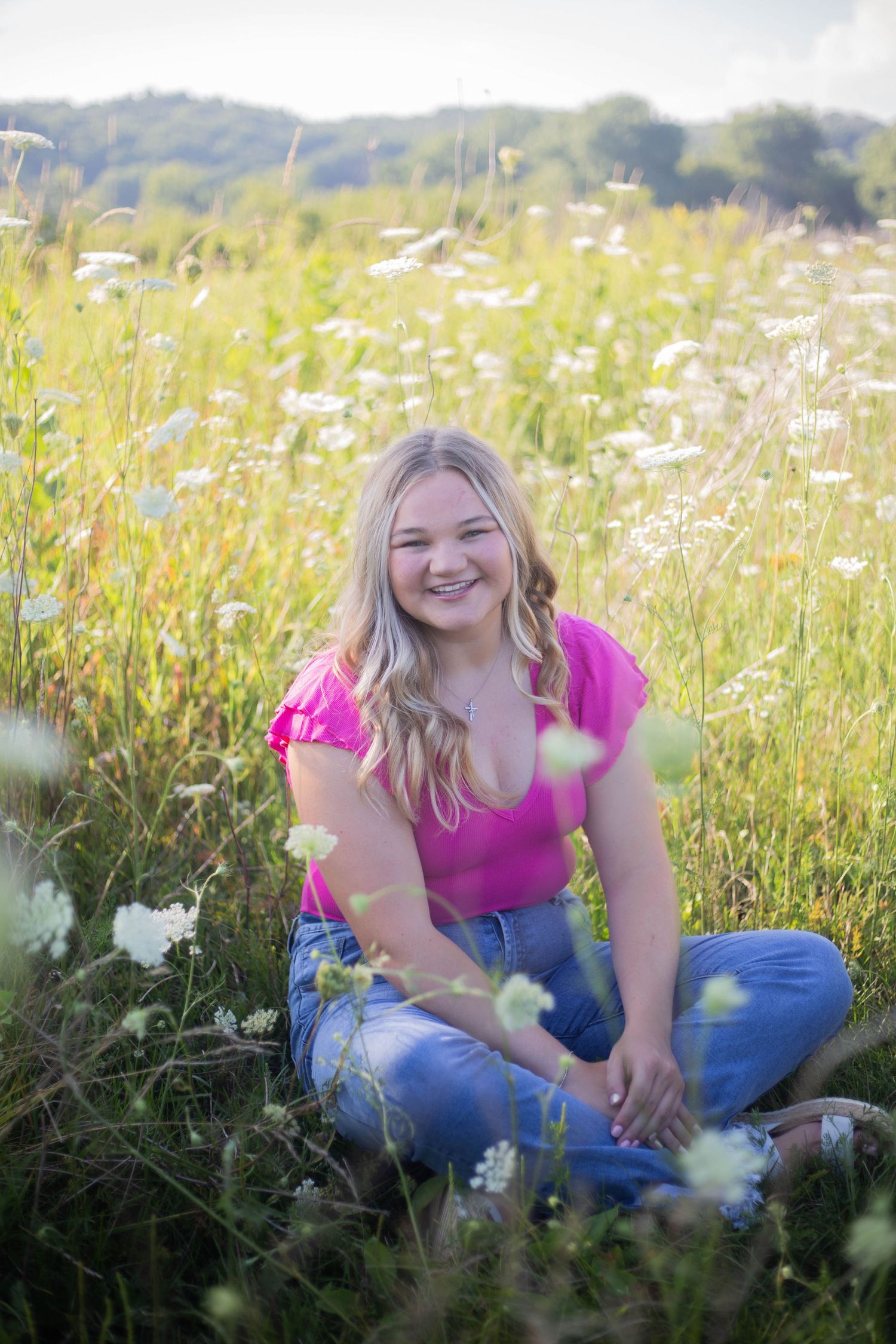 Casual portraits in a wildflower meadow wearing bright pink top and jeans. Mauston photographer.
