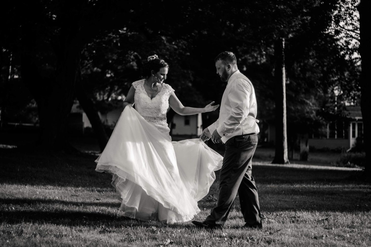 Wedding couple dances on grass in black and white photograph. Mauston photographer.