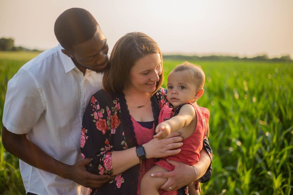 Tender family moment captured in a cornfield during golden hour sunset. Mauston photographer.