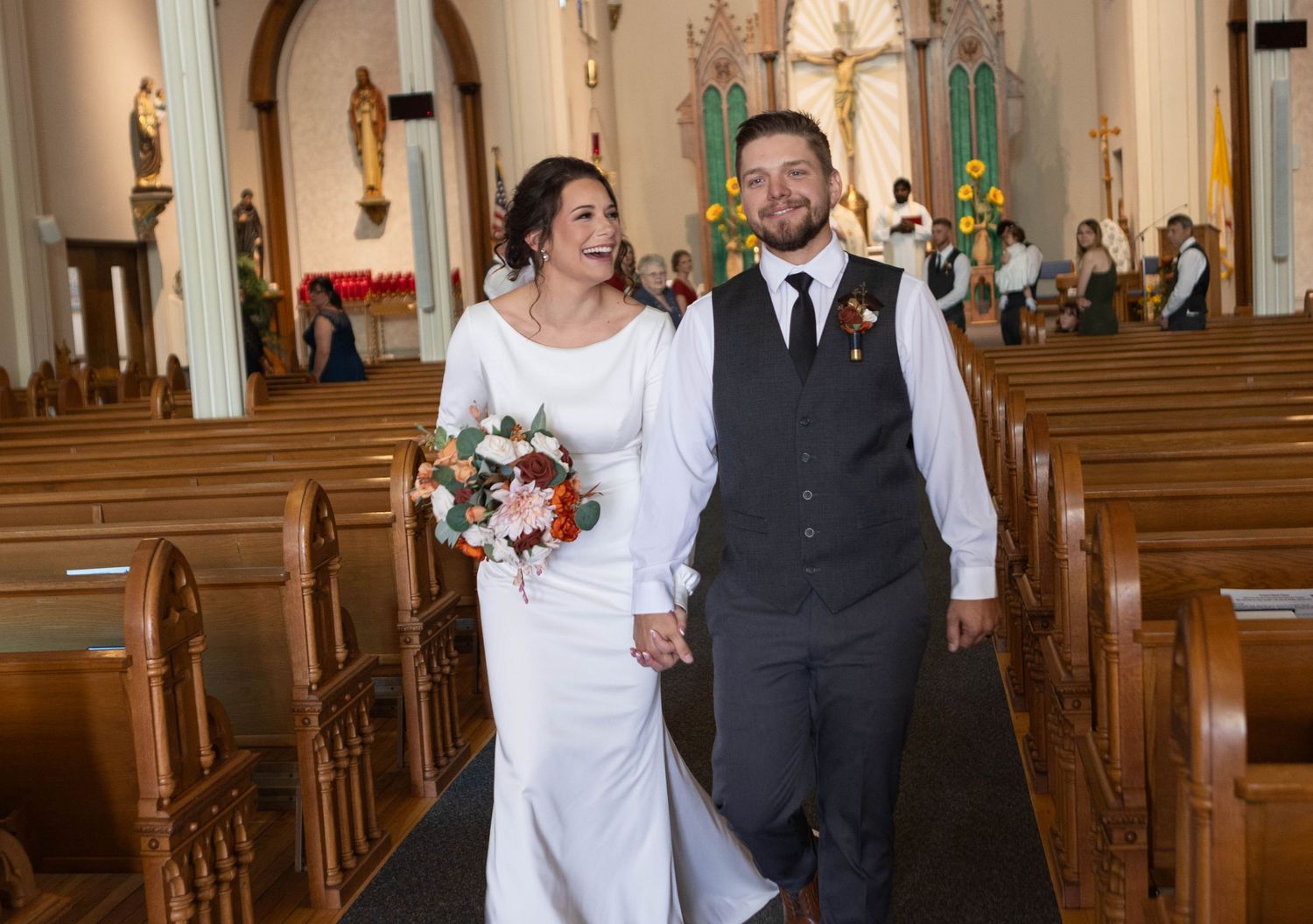 Wedding ceremony inside a traditional church with elegant architecture and wooden pews. Mauston photographer.