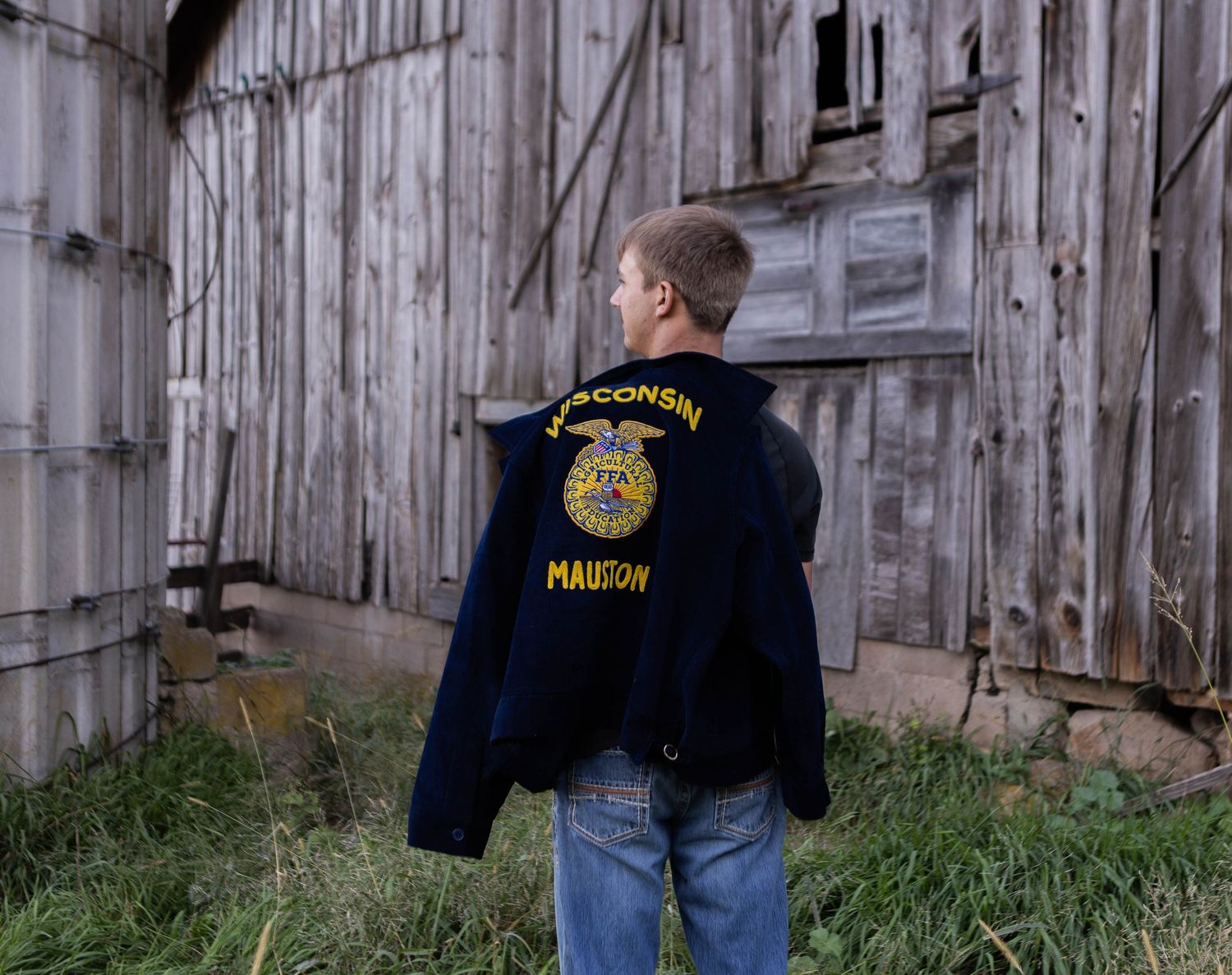 Law enforcement personnel examining area near rustic wooden barn structure. Mauston photographer.