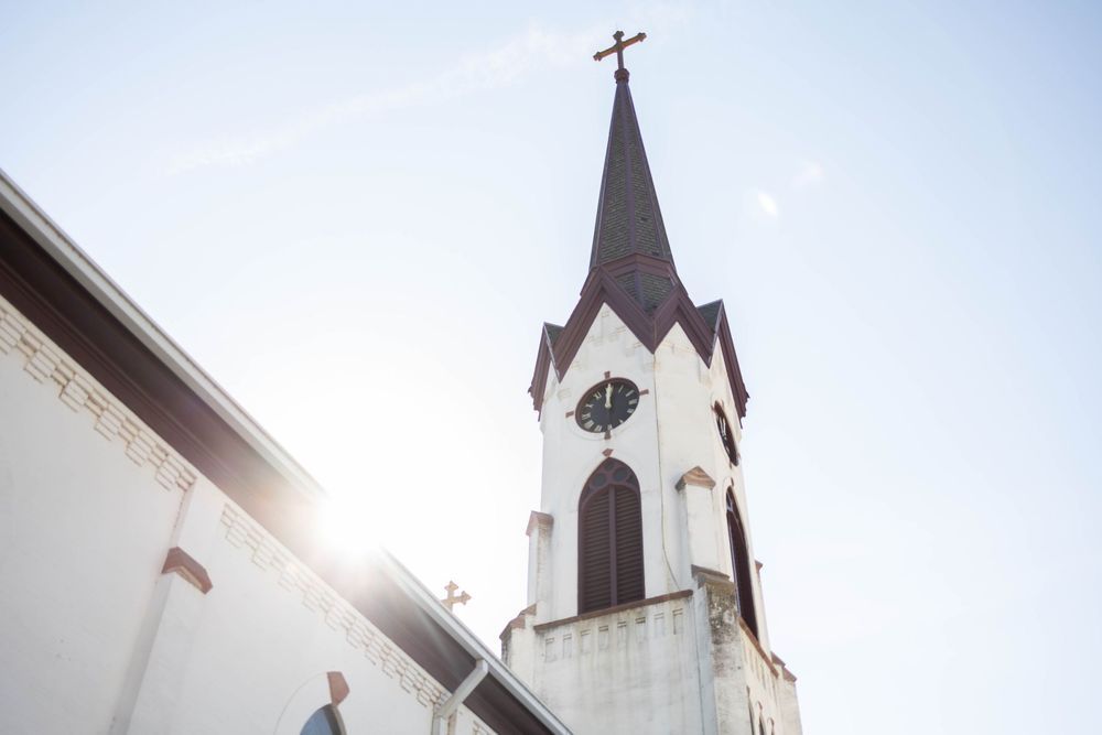 Church steeple with cross photographed against bright sky from different angles. Mauston photographer.