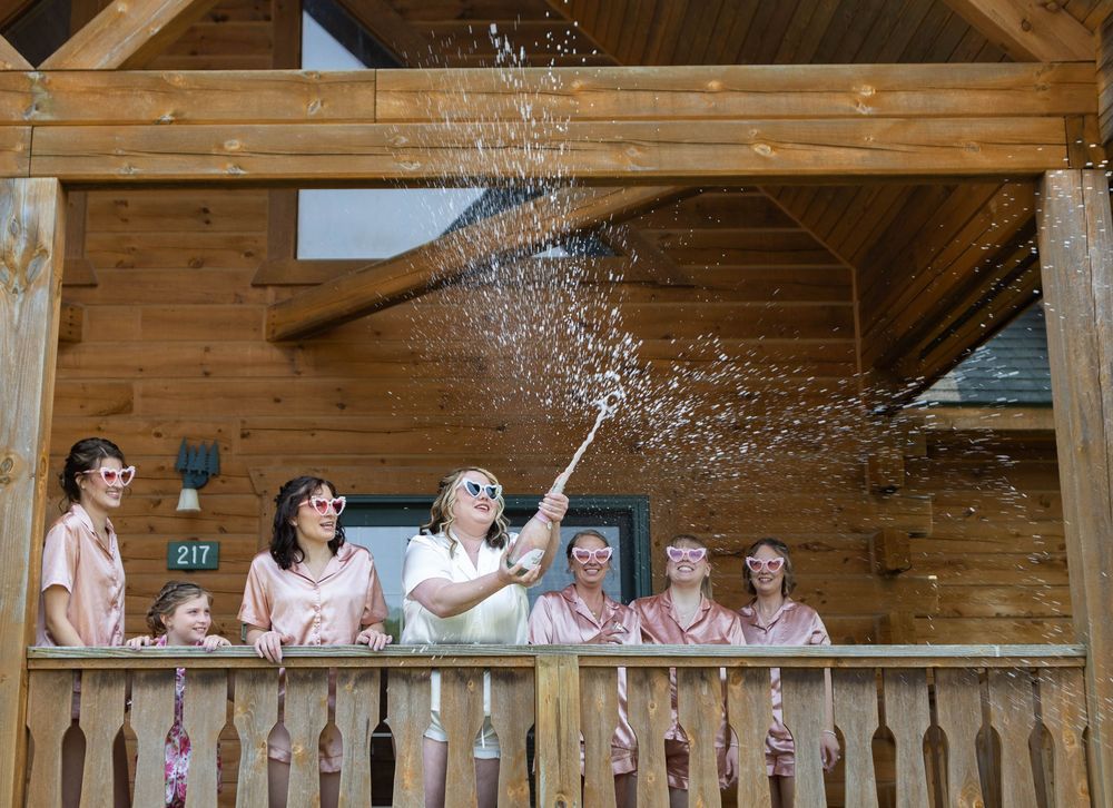 Wedding celebration scene in a rustic wooden venue with decorative lights and festive atmosphere. Mauston photographer.
