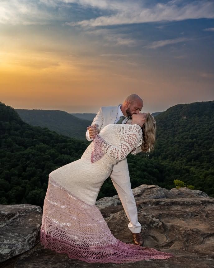Groom dipping bride in pink crochet wedding gown at sunset on scenic mountain overlook. Tennessee- Fall Creek Falls State Park