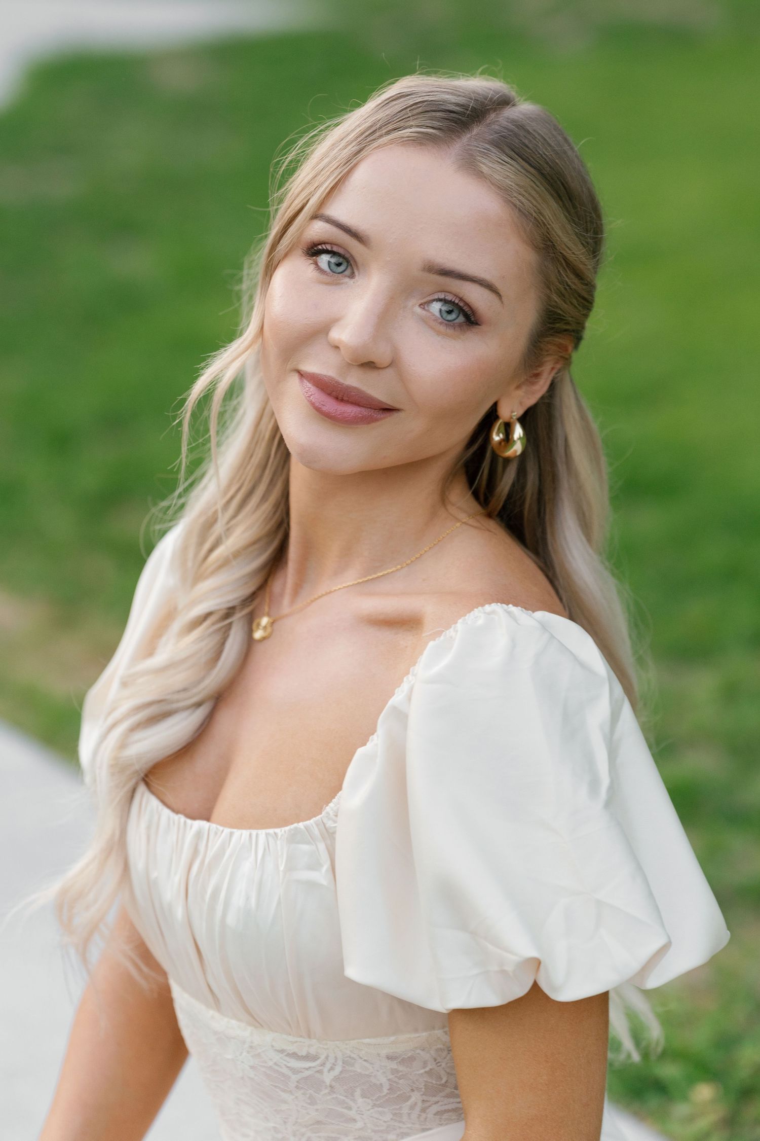 Portrait sequence of a woman in a white dress with flutter sleeves against a green background.
