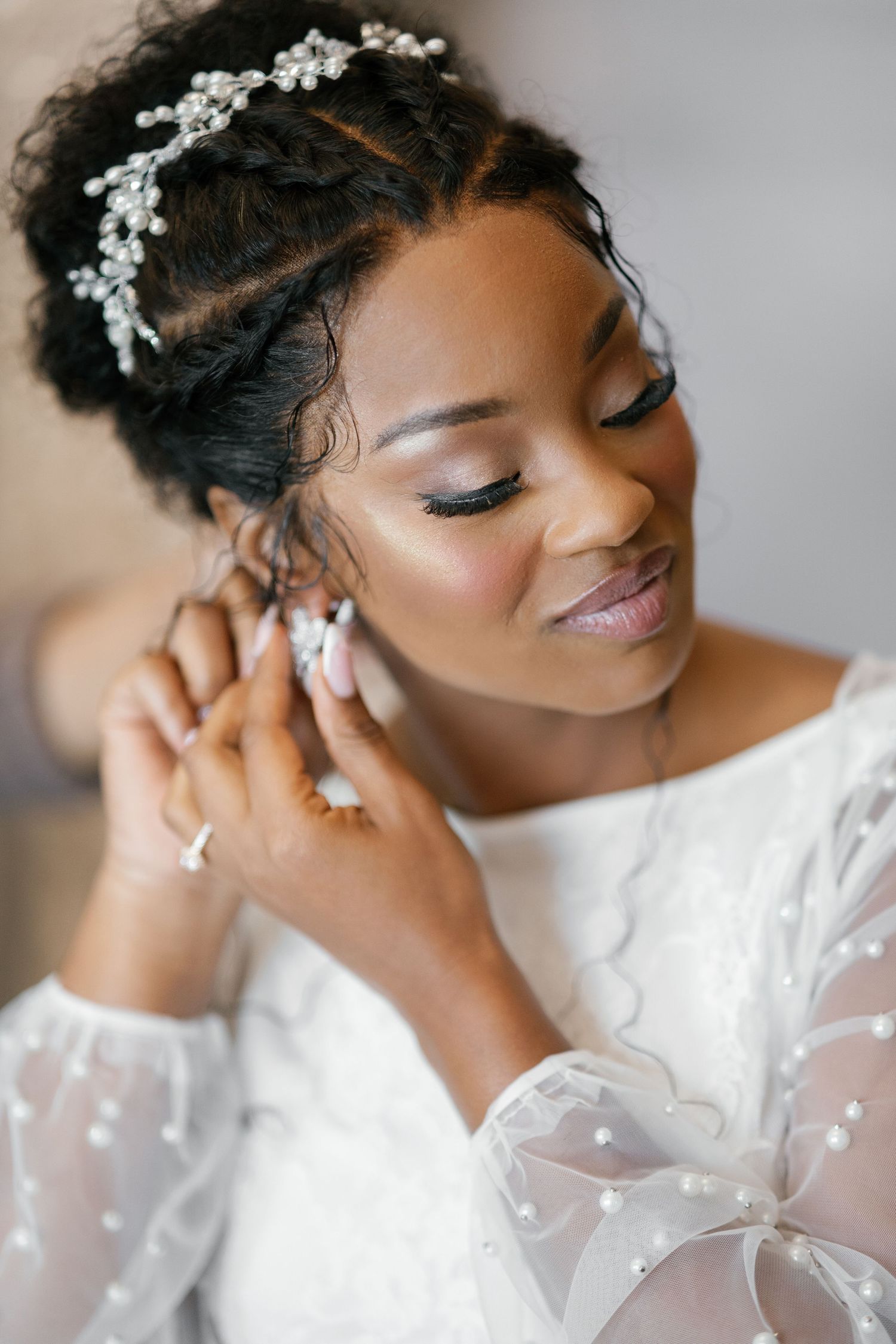 Close-up beauty shots of a bride wearing a crystal hair accessory and white gown.