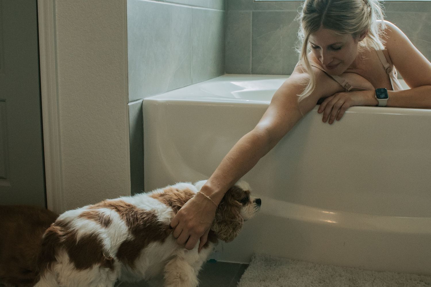 Copperas Cove Birth Photographer captures woman laboring in tub with support dog.
