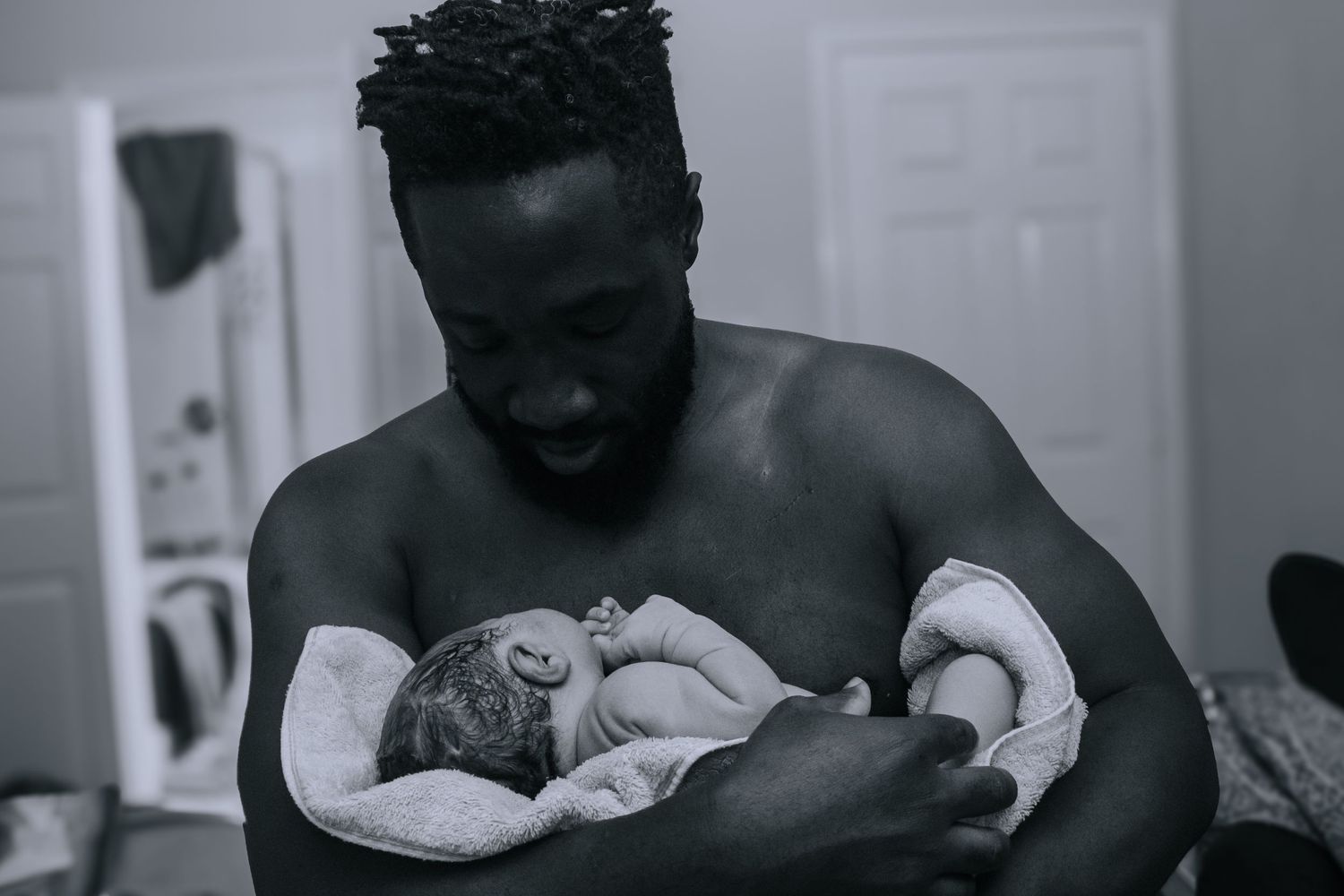 Killeen Birth Photographer captures father giving skin to skin care to newborn baby boy.
