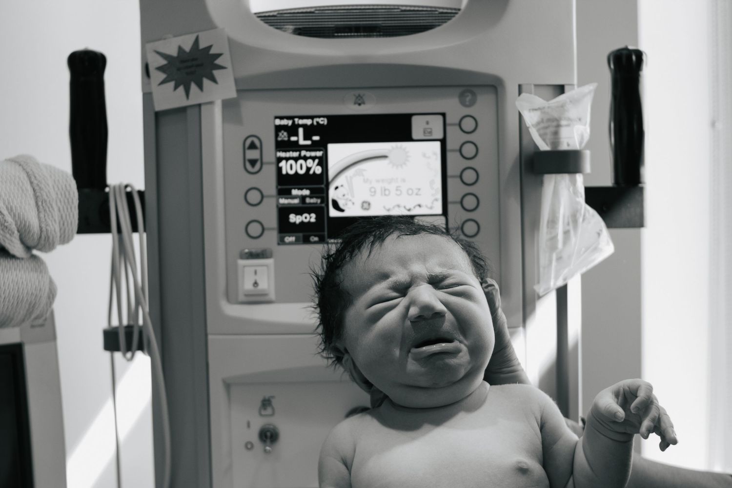 Fort Hood Birth Photographer captures 9 pound baby being weighed at the hospital after birth.
