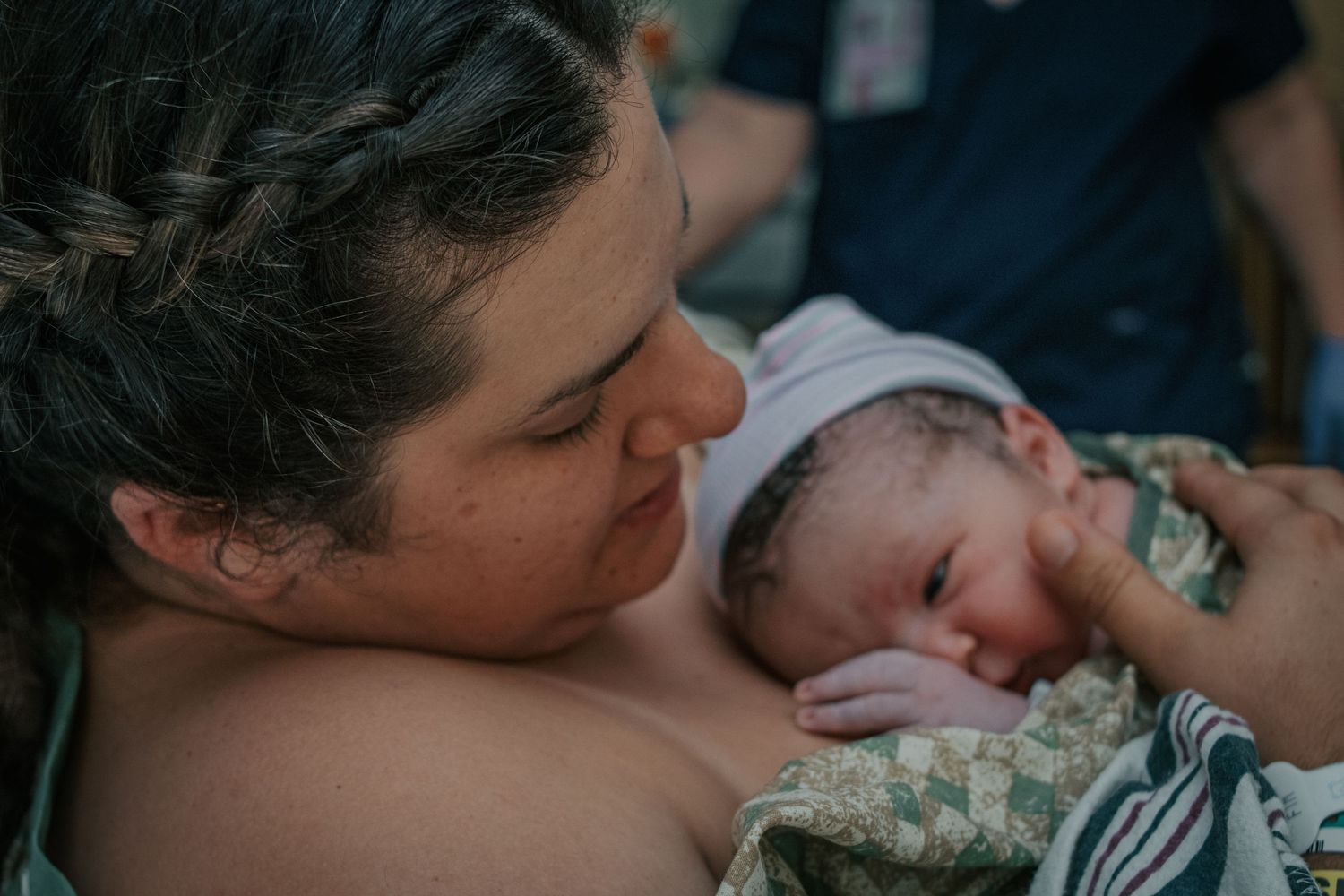 Georgetown Birth Photographer captures mother inspecting newborn baby.