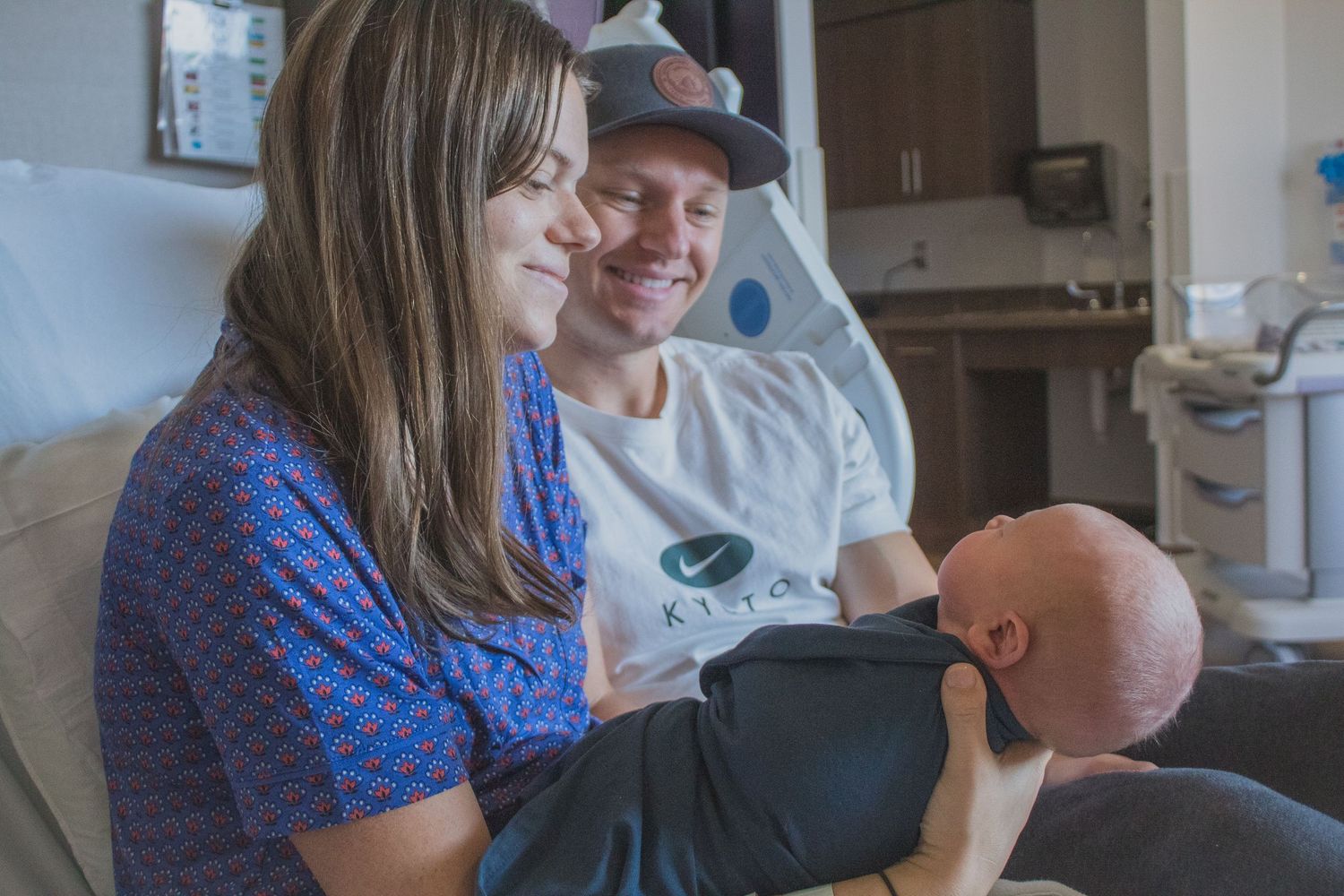 Fresh 48 Photographer capturing parents smiling and newborn baby.