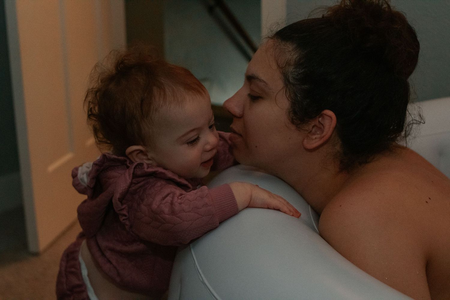 Fort Hood Birth Photographer captures baby girl trying to get into the birth pool with her laboring mother.