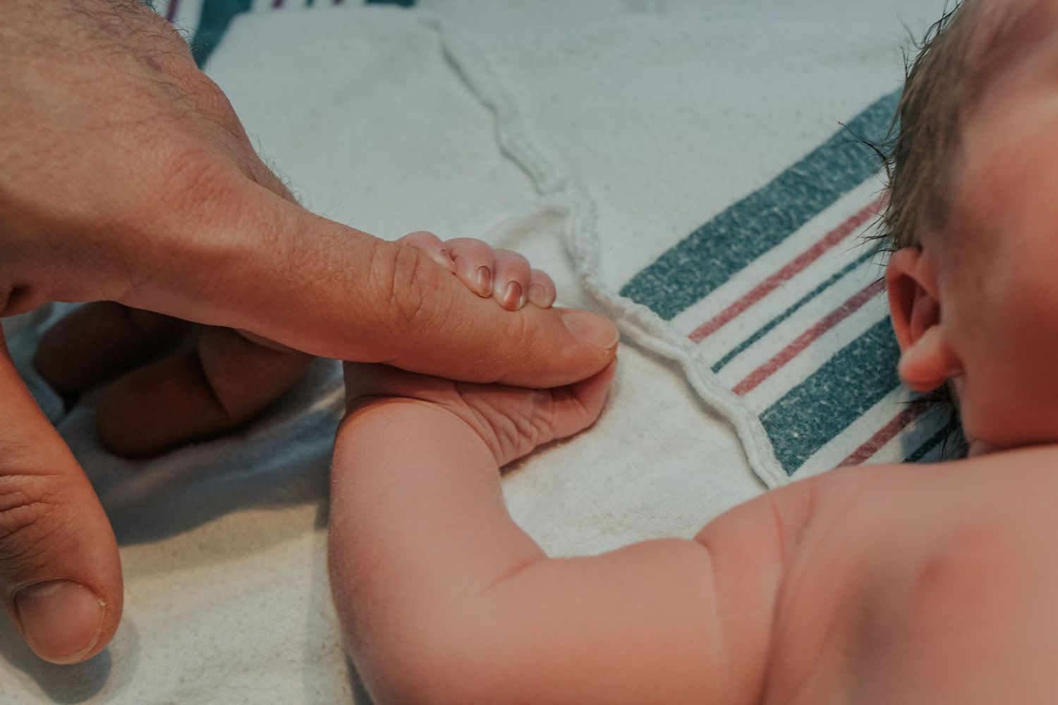 Georgetown Birth Photographer captures baby holding father's finger.