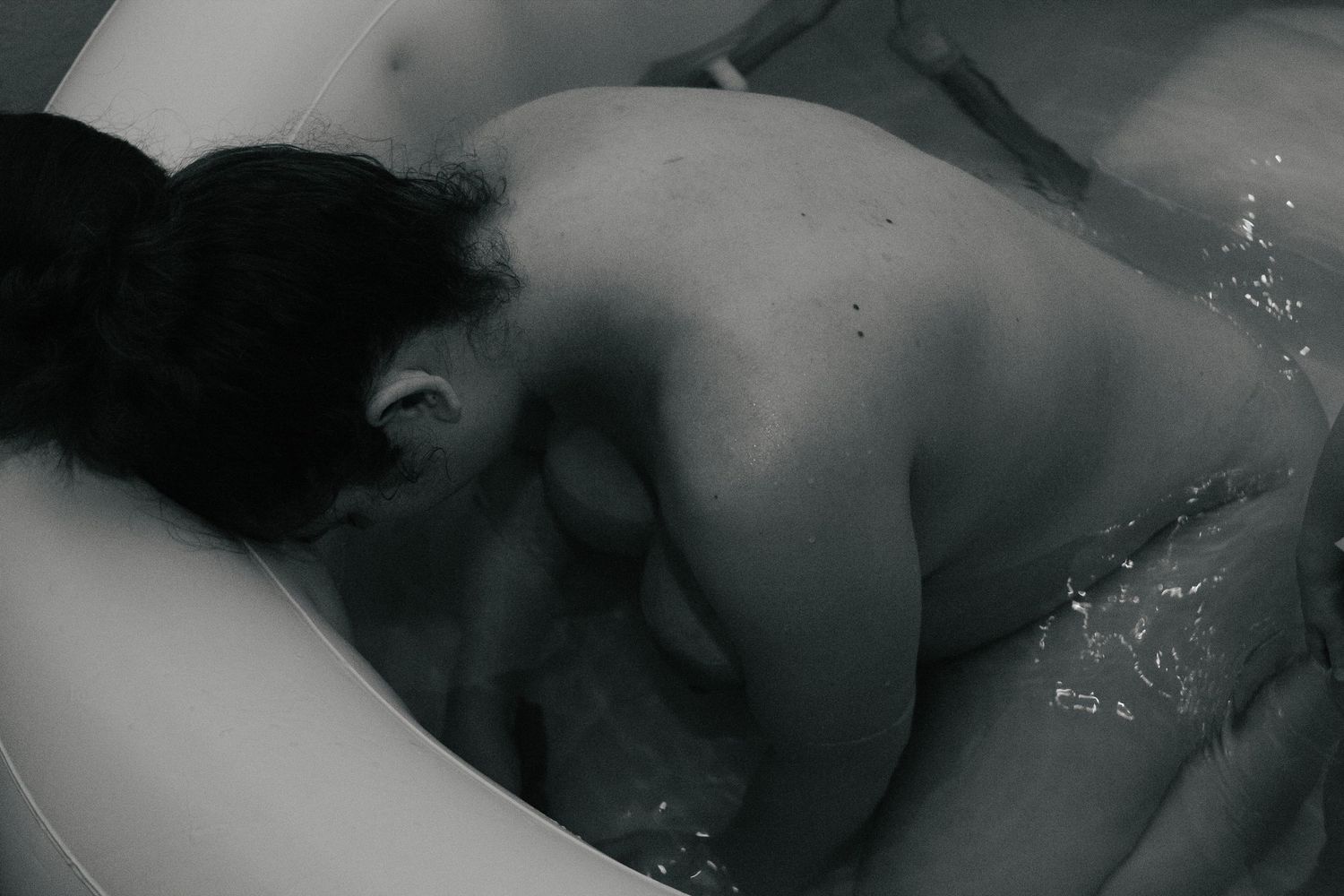 Fort Hood Birth Photographer captures mother peacefully laboring in the birth pool at home.