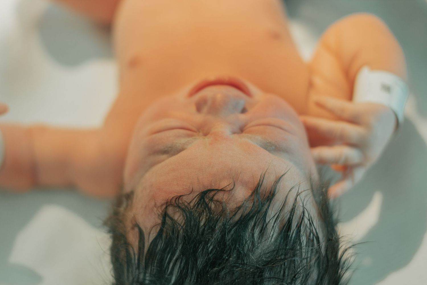 Fort Hood Birth Photographer captures crying baby in warmer moments after birth.