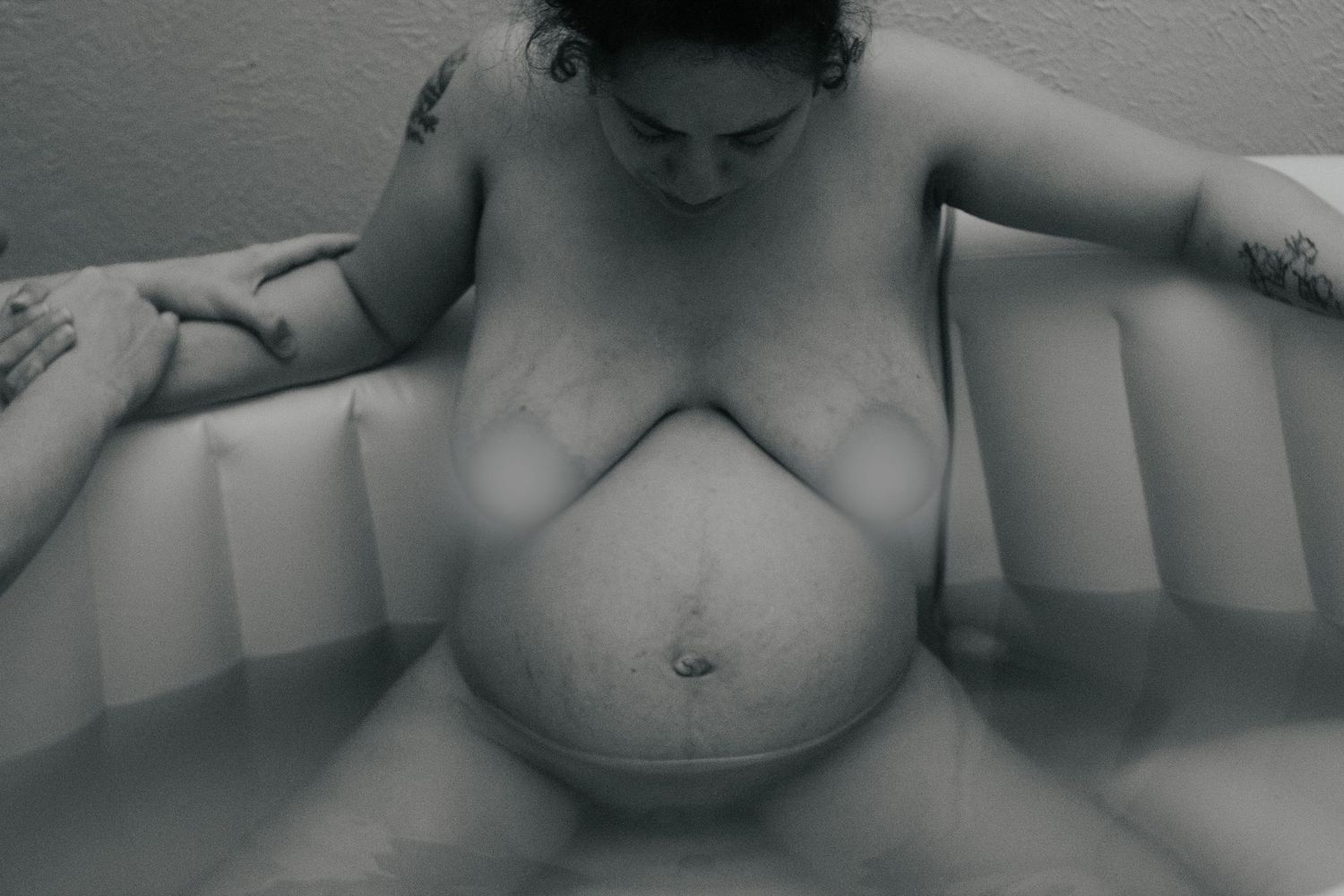 Fort Hood Birth Photographer captures mother attempting a different labor position in the birth pool.
