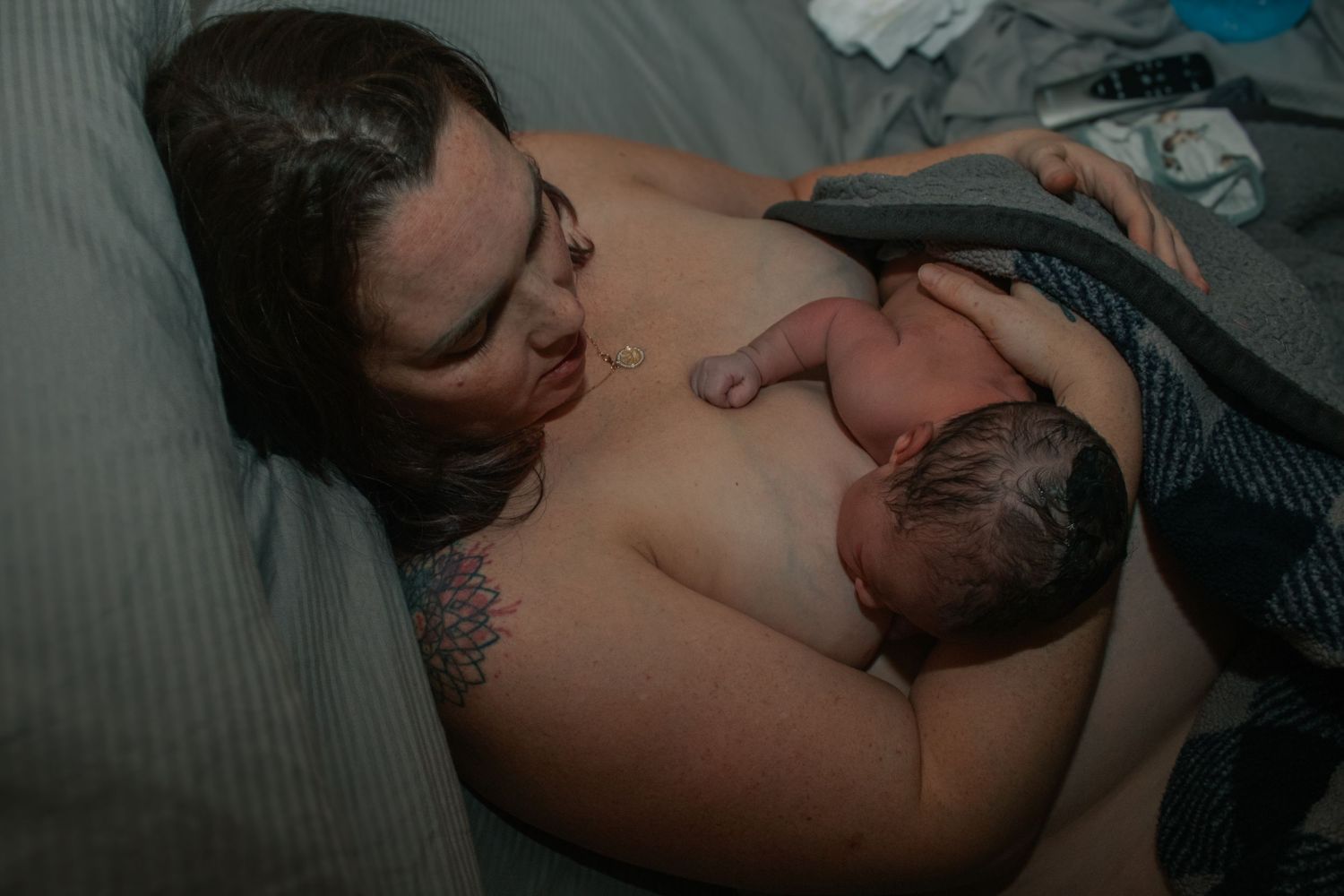 Killeen doula capture image of mother breastfeeding newborn baby for the first time in the comfort of her own bed.