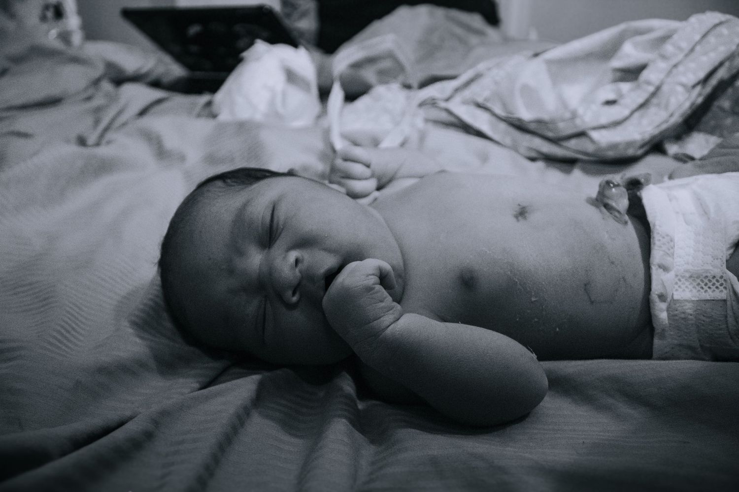 Killeen birth photographer captures baby boy laying on bed.