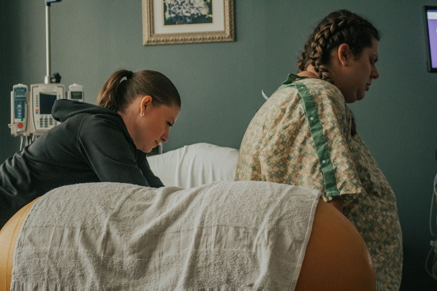 Christian doula supporting laboring mother in hospital birth.