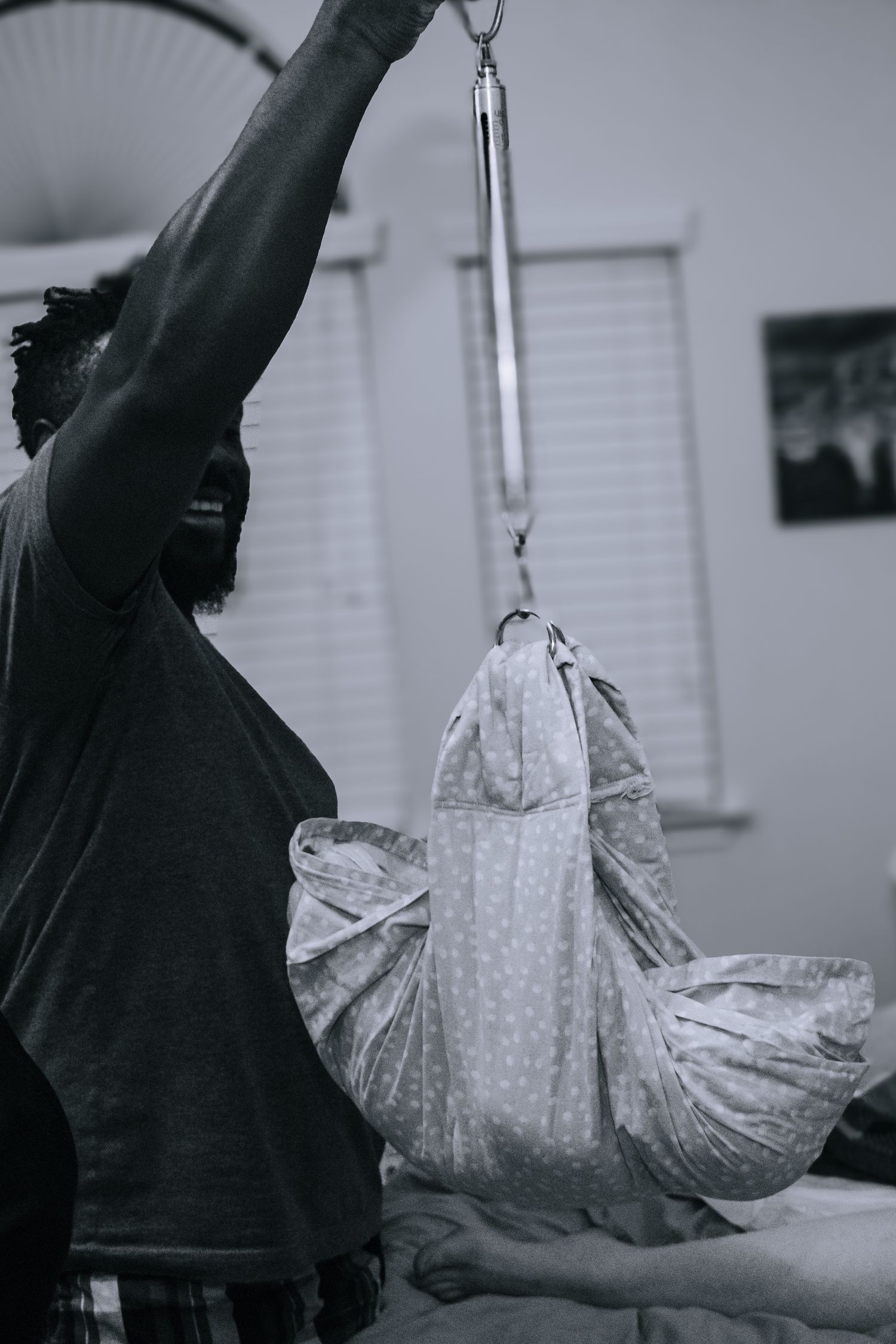 Killeen Birth Photographer captures dad weighing baby boy in sling.