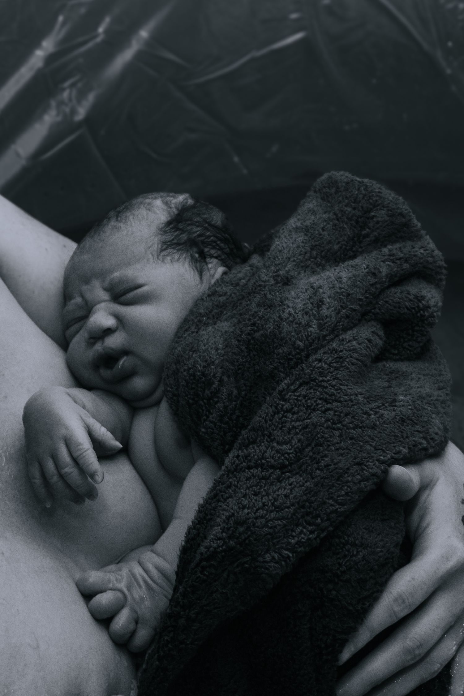 Killeen Birth Photographer captures newborn baby in mother's arm in water birth.