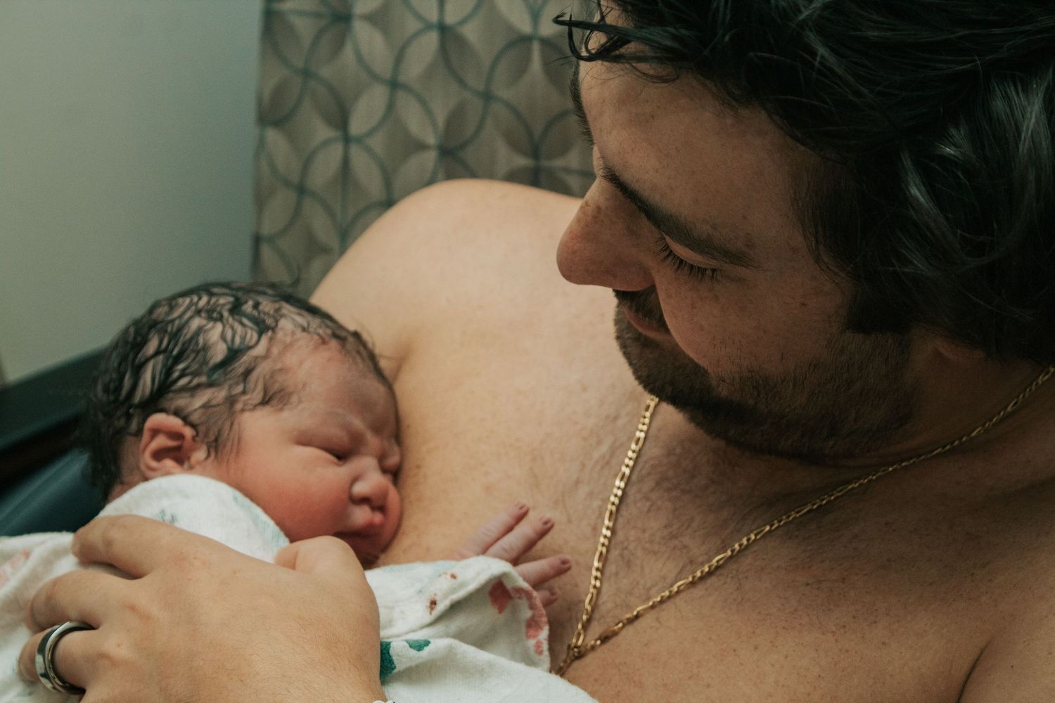 Copperas Cove Birth photographer capturing father holding newborn baby skin to skin.