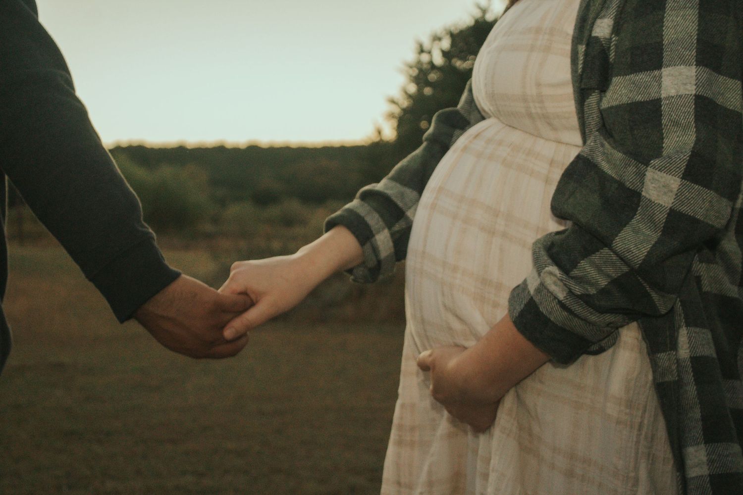 copperas cove maternity photographer capturing pregnant mother holding hands with father.