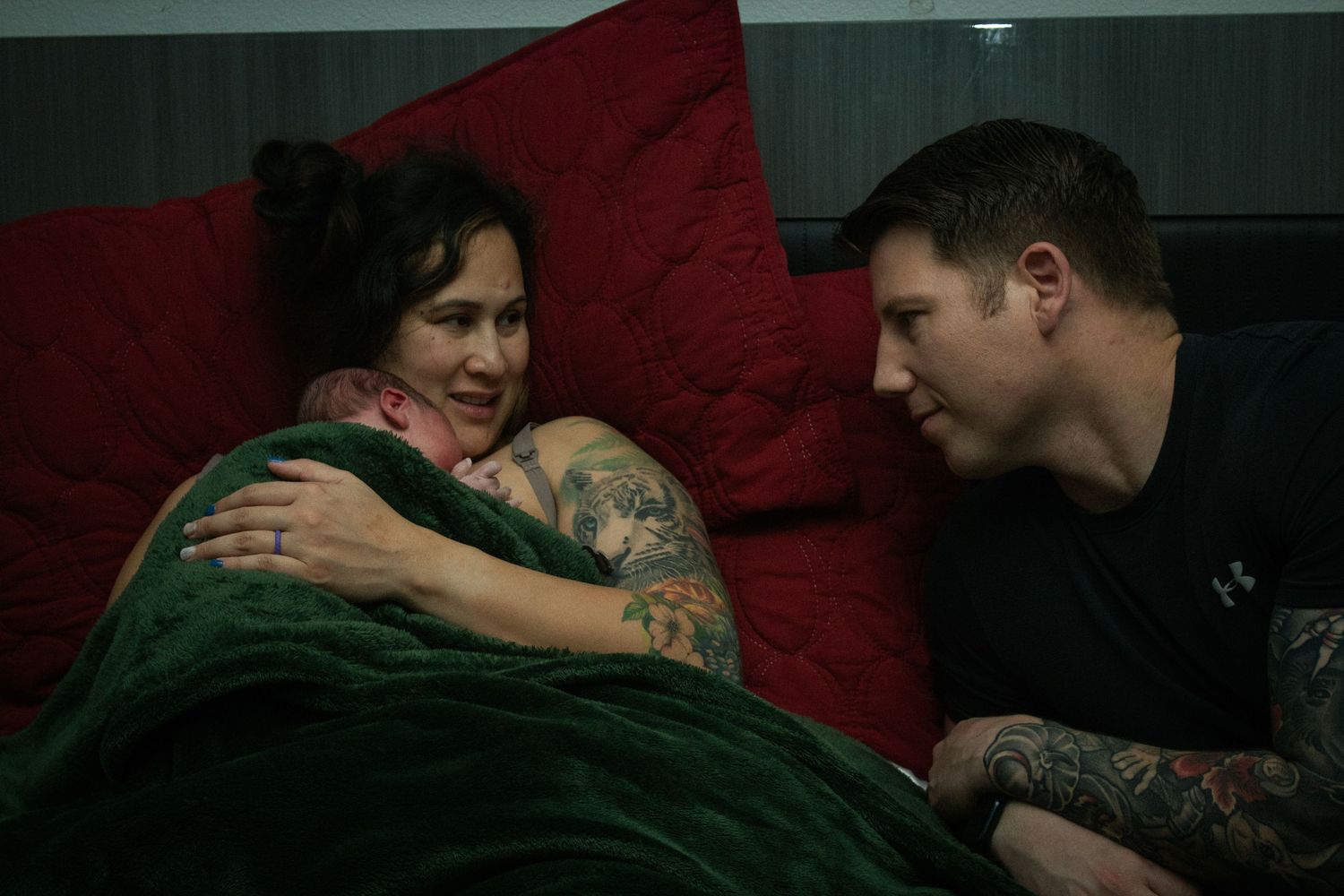 Harker Heights doula captures image of parents holding newborn baby in bed after homebirth