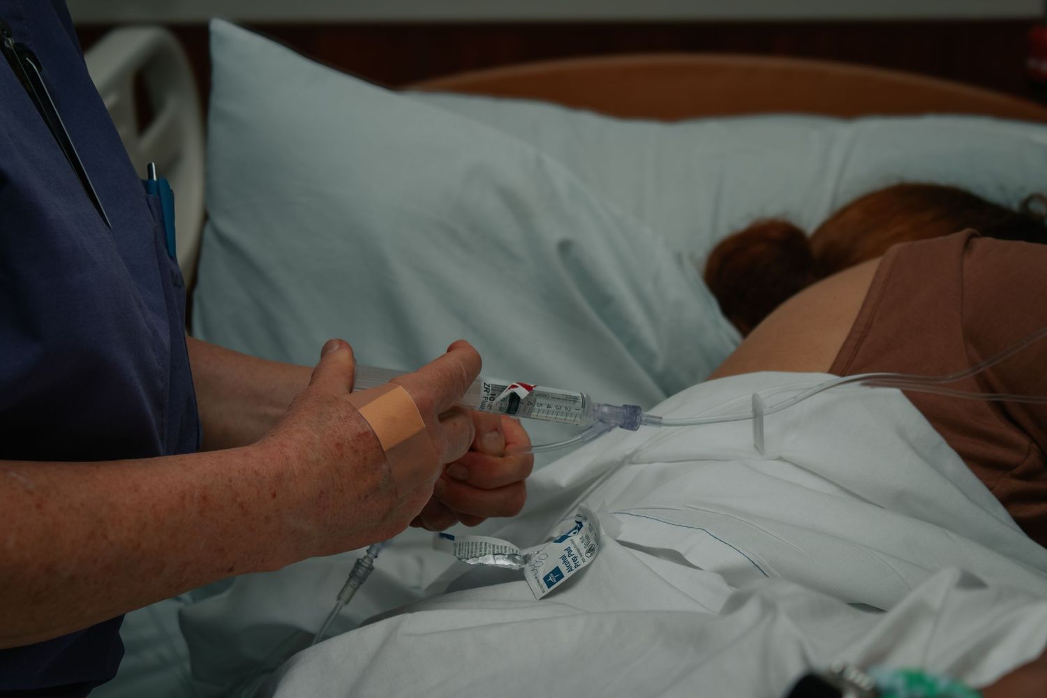 Copperas Cove birth photographer capturing laboring mother receving IV narcotics.