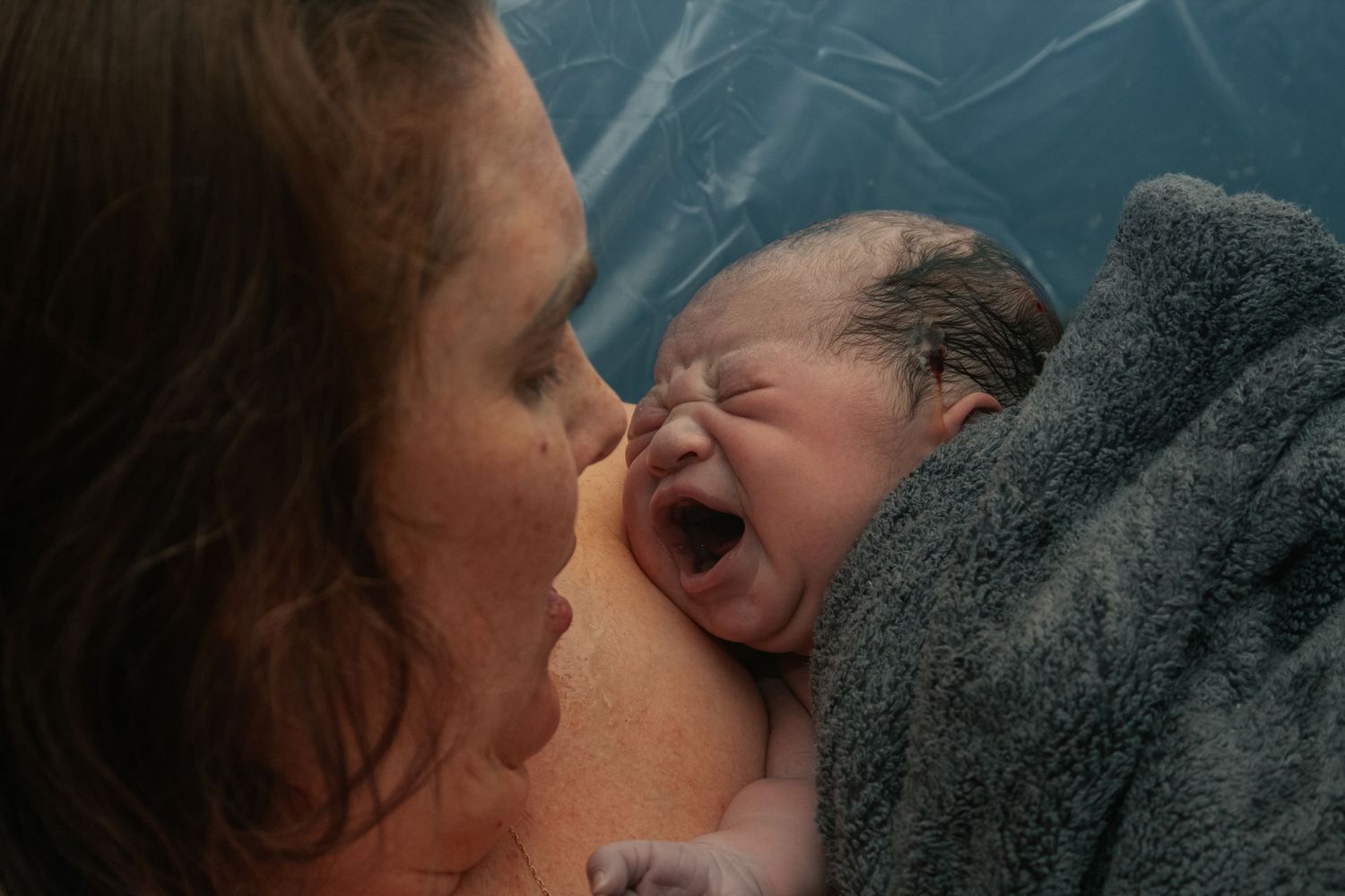 Copperas Cove Birth Photographer capturing mother holding baby immediately after home birth.