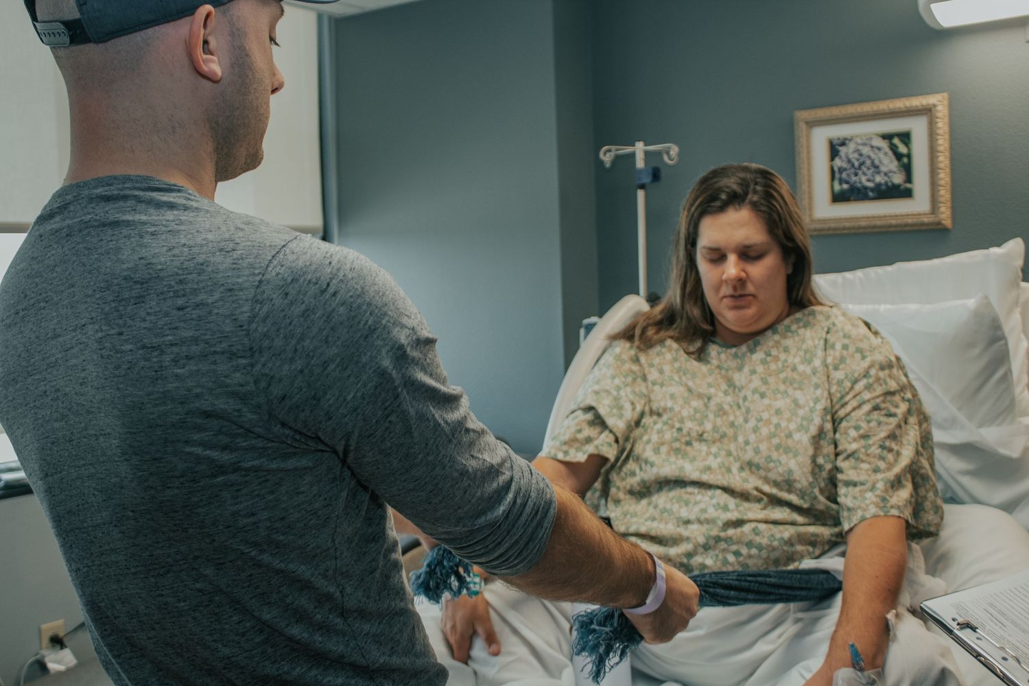 Georgetown Birth Photographer captures husband using the rebozo to ease discomfort of labor contractions.
