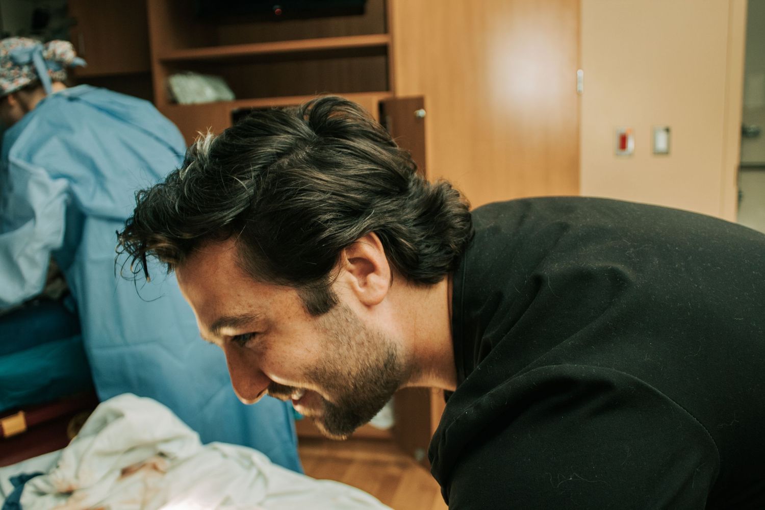 Copperas Cove Birth Photographer captures father smiling at newborn baby and warrior wife.