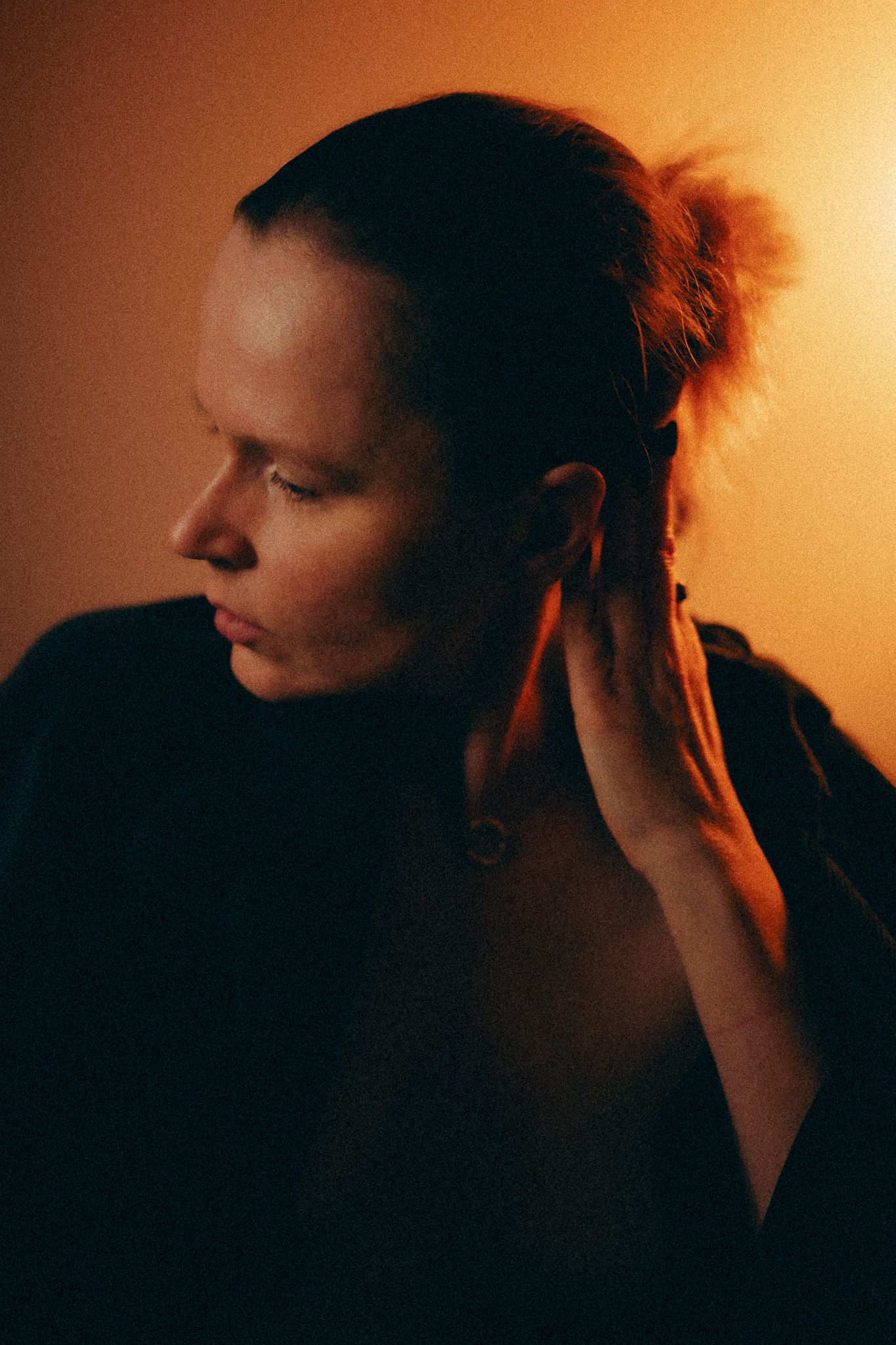 Profile portraits in orange lighting showing expressive poses and movements.