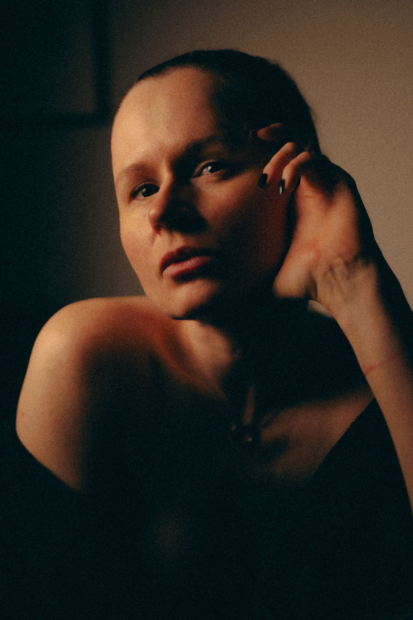 Intimate close-up portraits with warm tones and dramatic shadow play.
