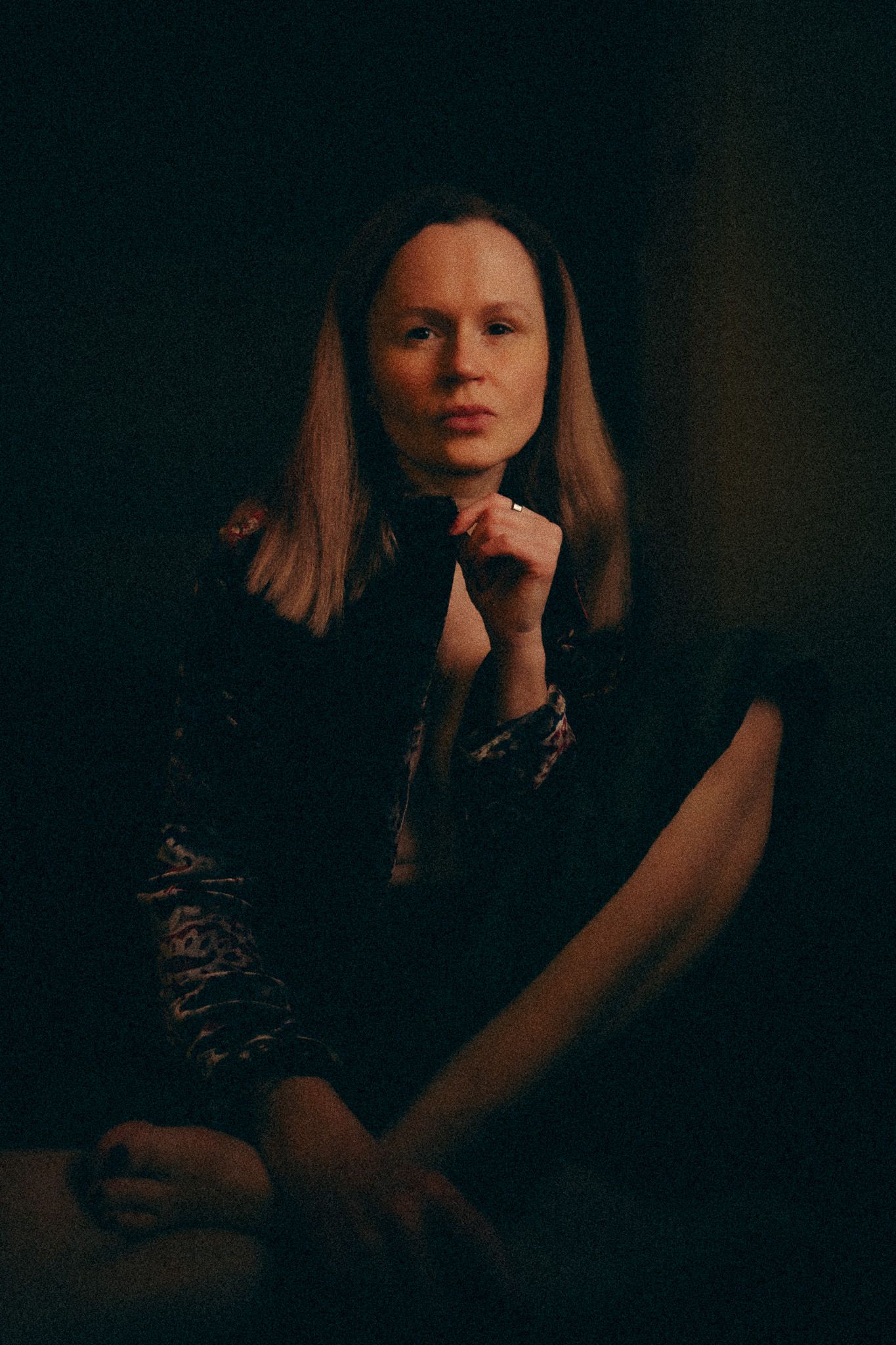 Moody portrait series in dark lighting shows figure with long hair in dramatic shadows.
