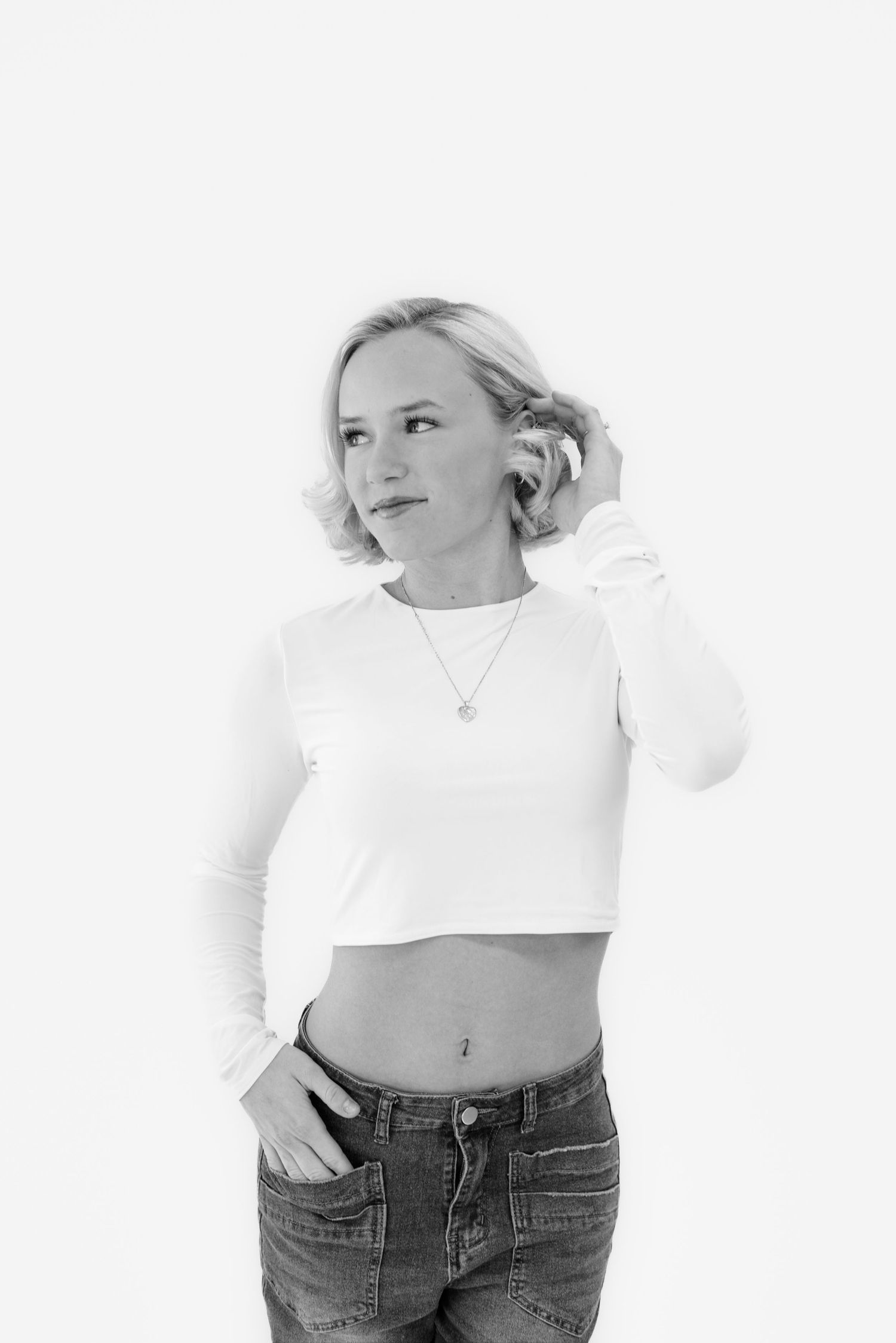 Minimalist studio portraits showing casual poses in white top and denim.