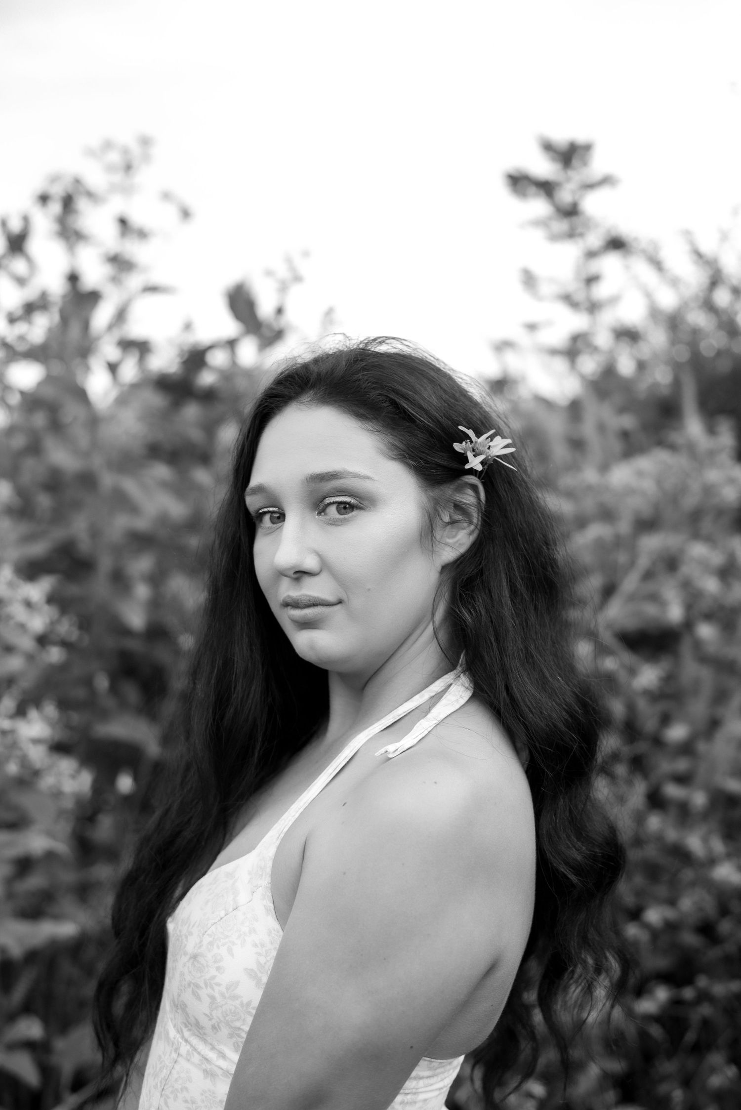A black and white portrait features a person wearing a delicate hair accessory.