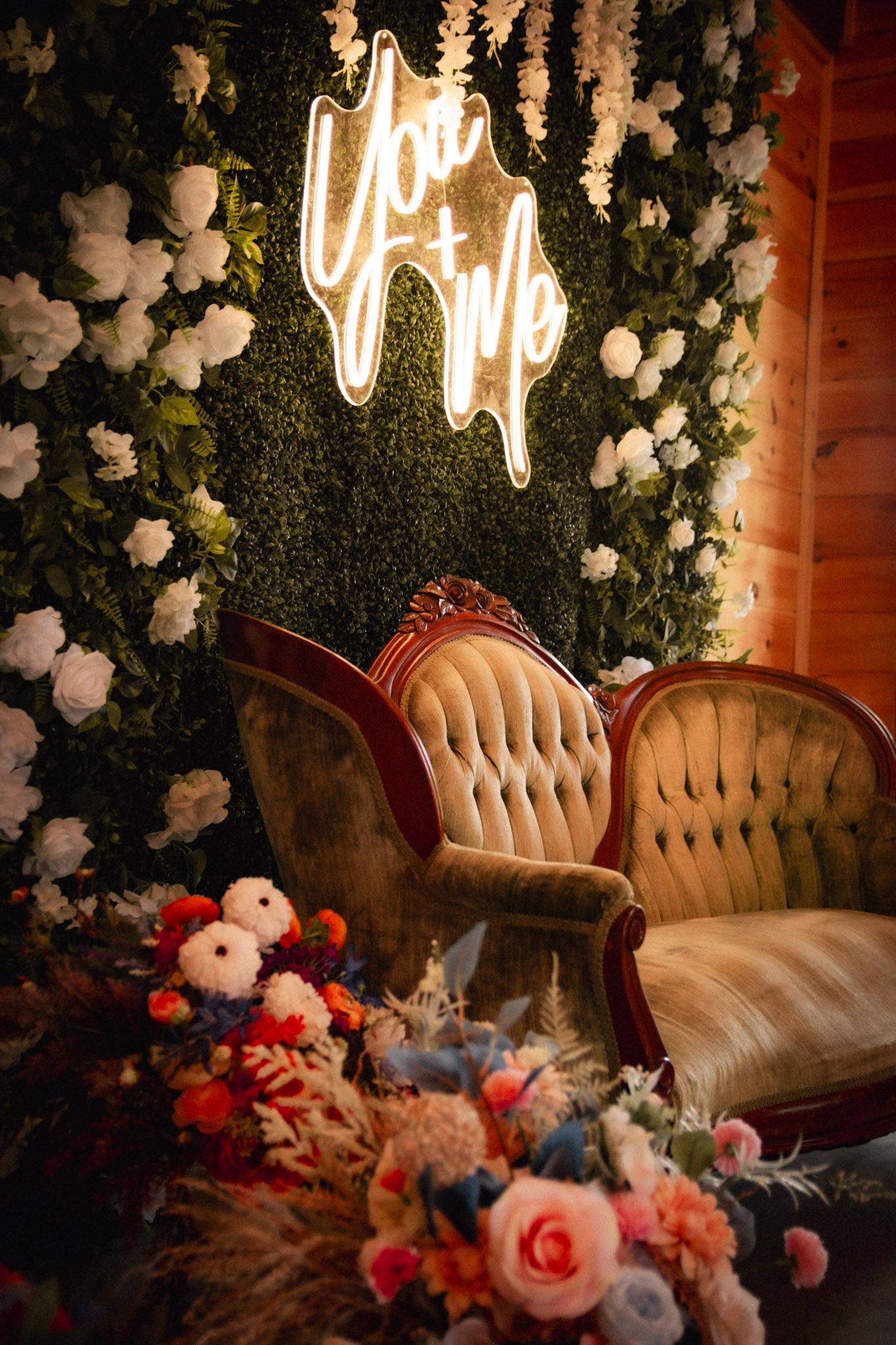 Elegant wedding lounge area with floral arrangements and illuminated signage.
