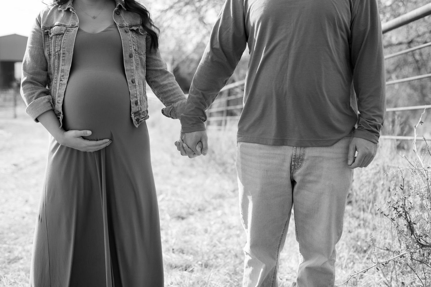 Side profile of expecting couple sharing tender moment in natural lighting.