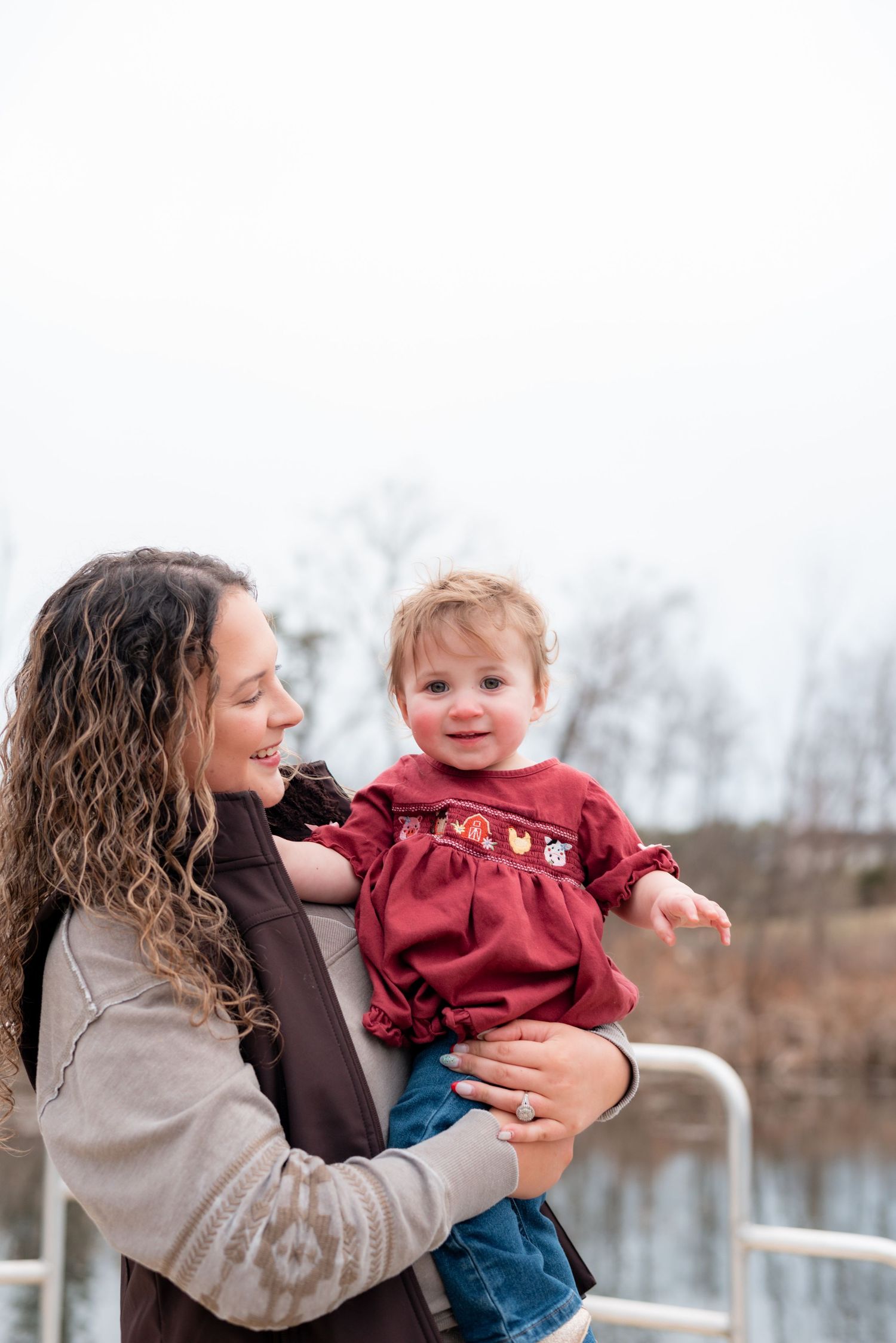 Playful outdoor moments captured between adult and child wearing burgundy against winter backdrop.