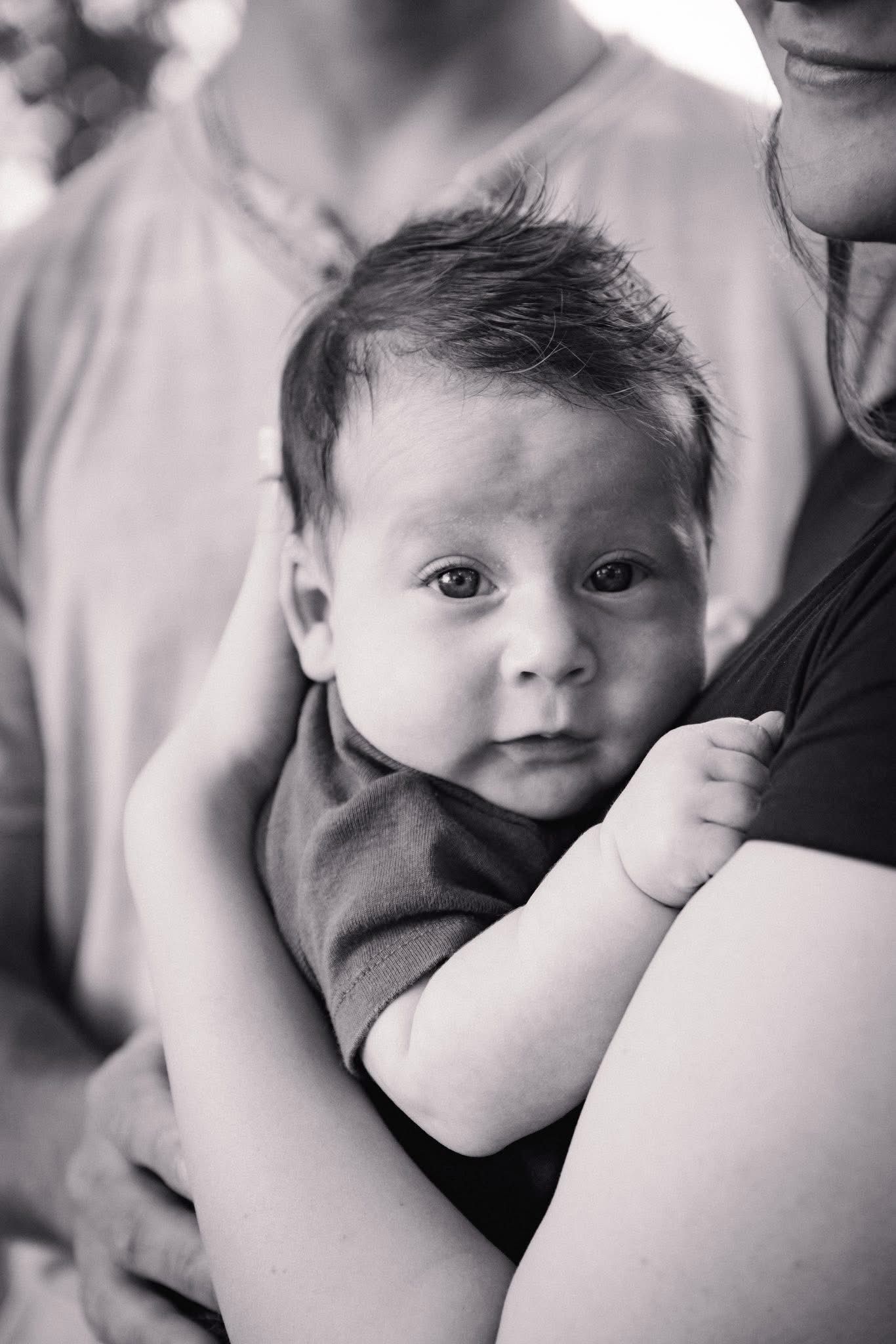 Series of intimate black and white close-up shots showing tender family moments.