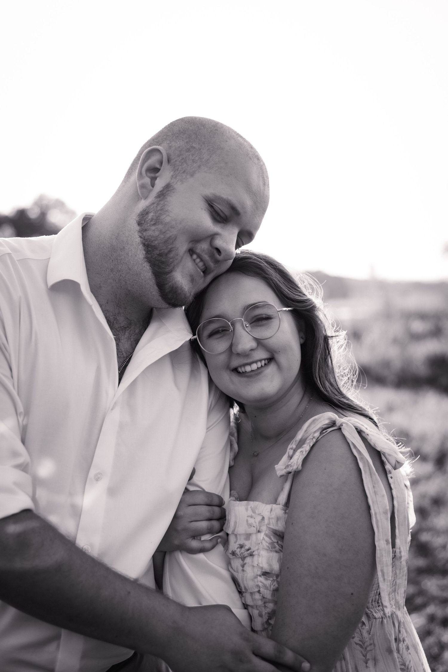 Intimate black and white portrait of a couple embracing outdoors.