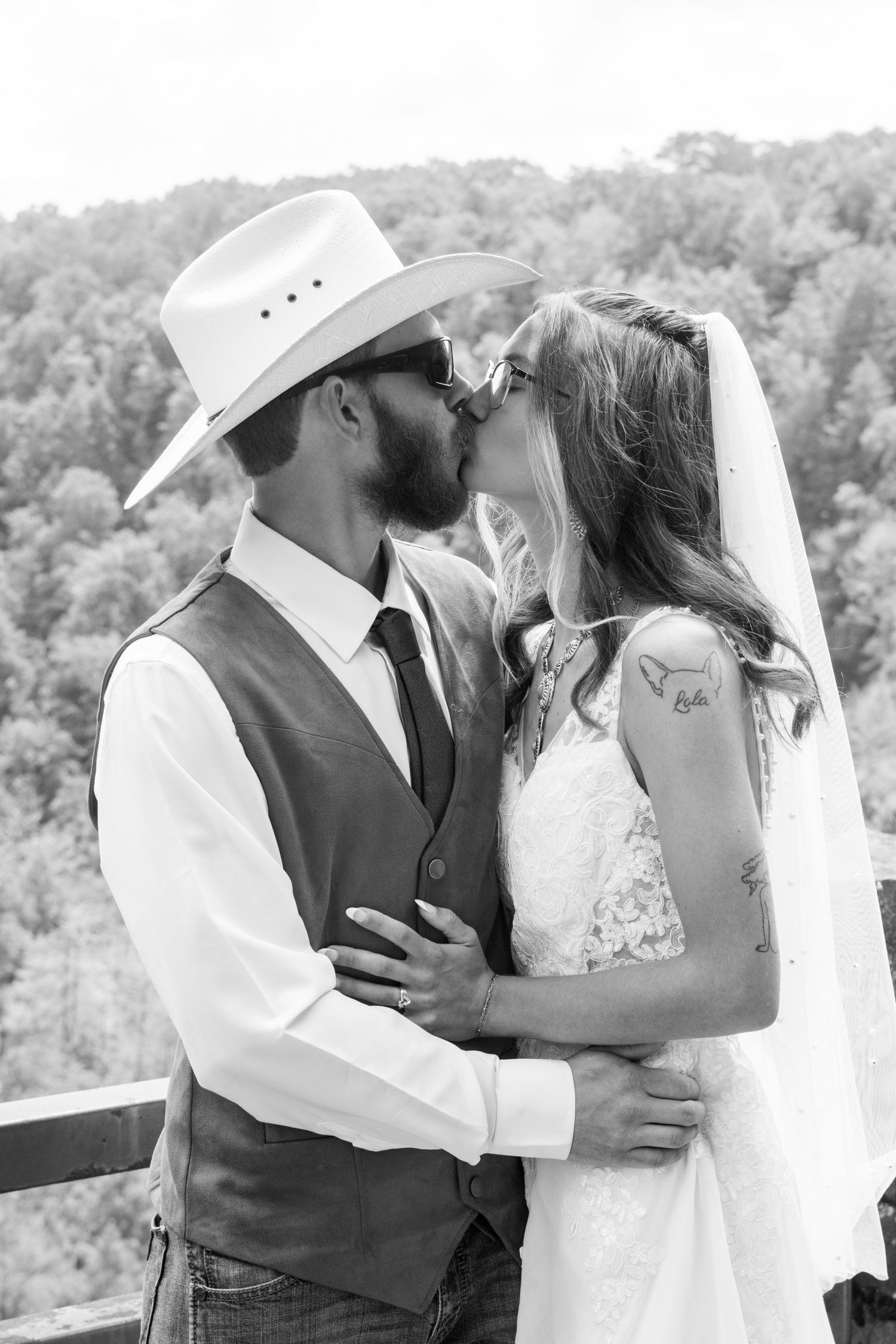 Black and white romantic wedding photos on an outdoor deck with mountain views.