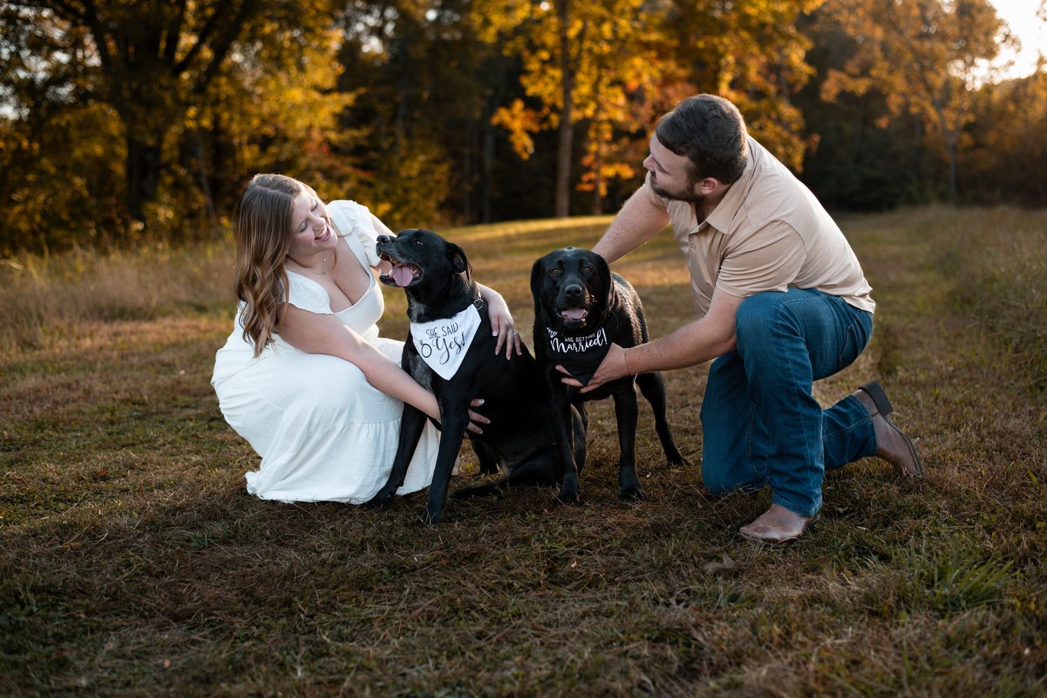 Playful couple relaxing on grass during outdoor autumn photoshoot.